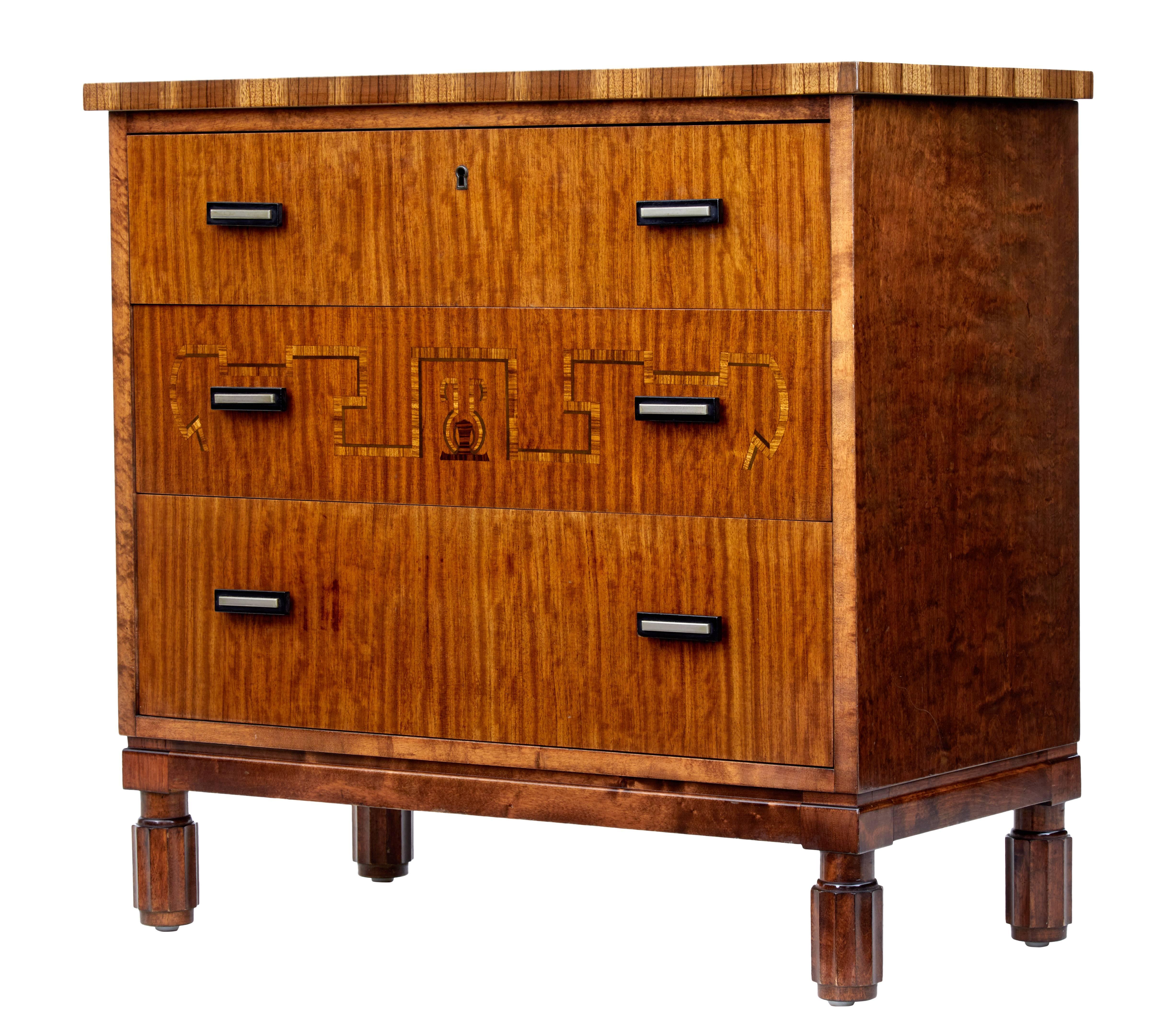 Good quality Scandinavian small chest of drawers in the Art Deco taste, circa 1950.

Three graduating mahogany drawers, middle drawer with inlay. Top drawer with working lock and key.

Fitted with ebonized wood and steel handles.

Standing on