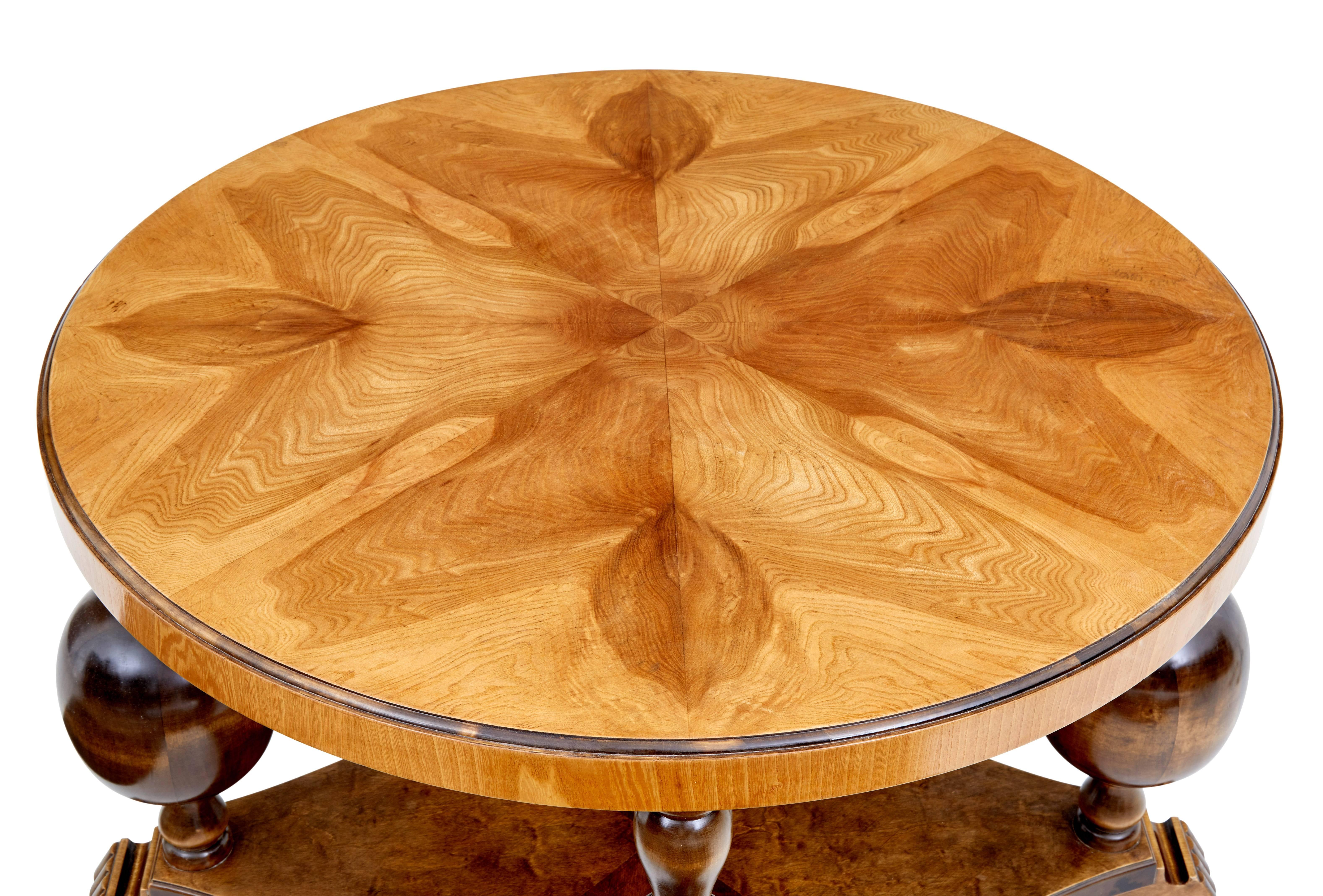 Fine quality Art Deco inspired coffee table, circa 1950.

Beautiful elm circular top, standing on 4 birch baluster support legs united by a lower shelf.