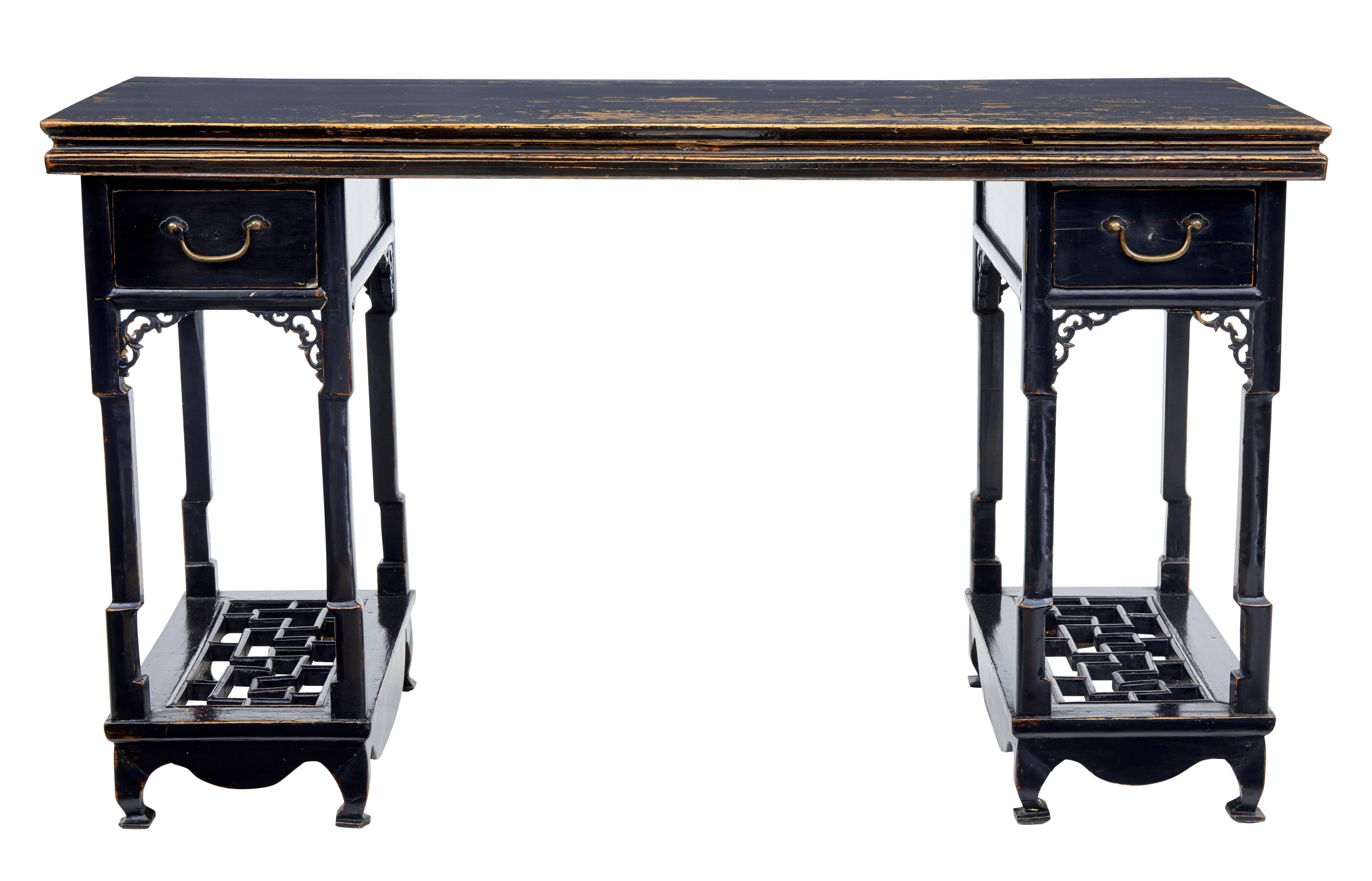 Chinese 19th century alter table, circa 1870.

Comprising of three parts, two pedestals and top surface. Presented in black lacquer which has worn through.

Now useful as a desk with a drawer in each pedestal and lower pierced carved shelf.