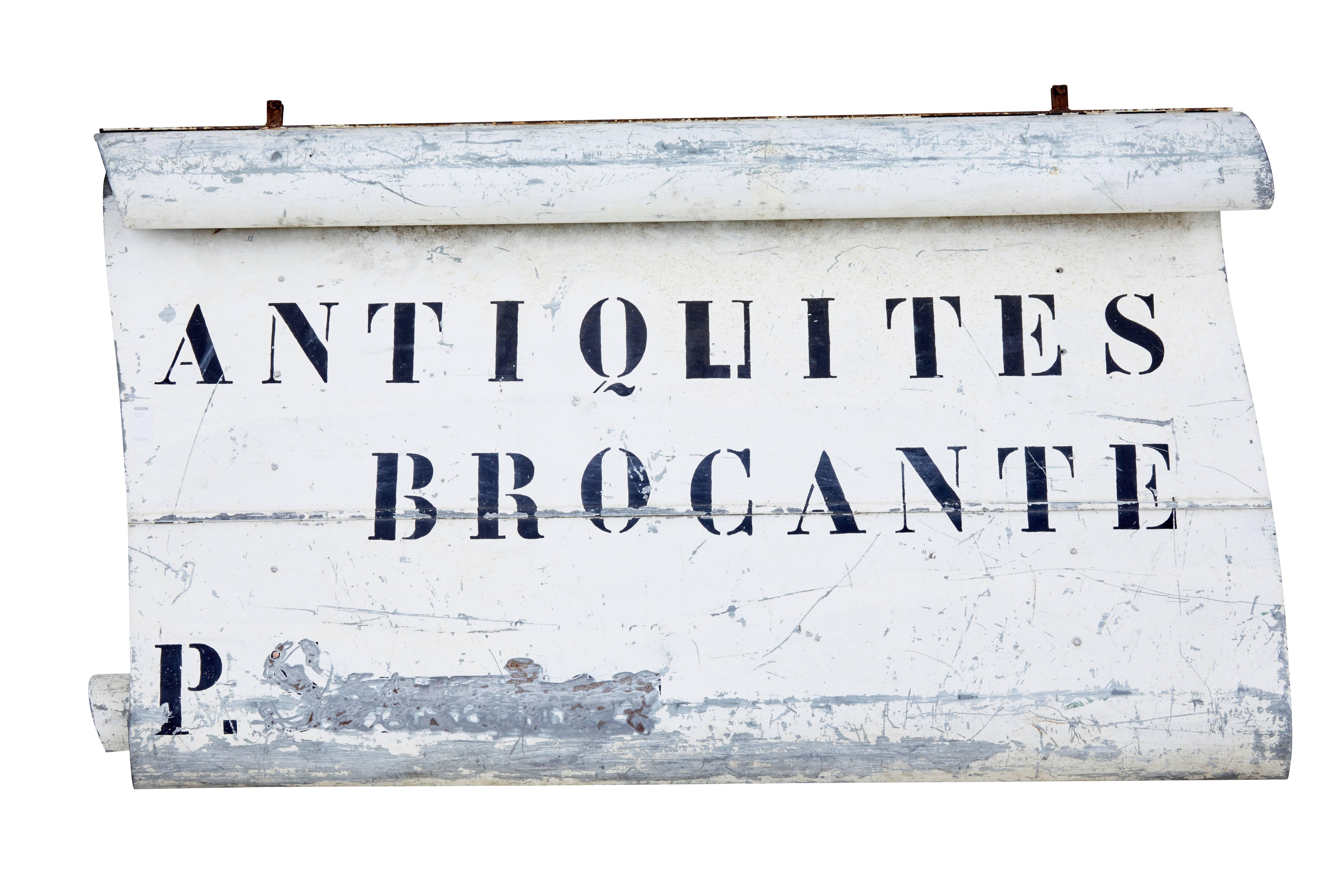 Here we present an unusual find of a French antique shop sign, circa 1920.

Shaped steel, painted with applied lettering in French which reads 'antiques and secondhand goods'. The dealers name has been crudly scratched out.

Brackets remain to