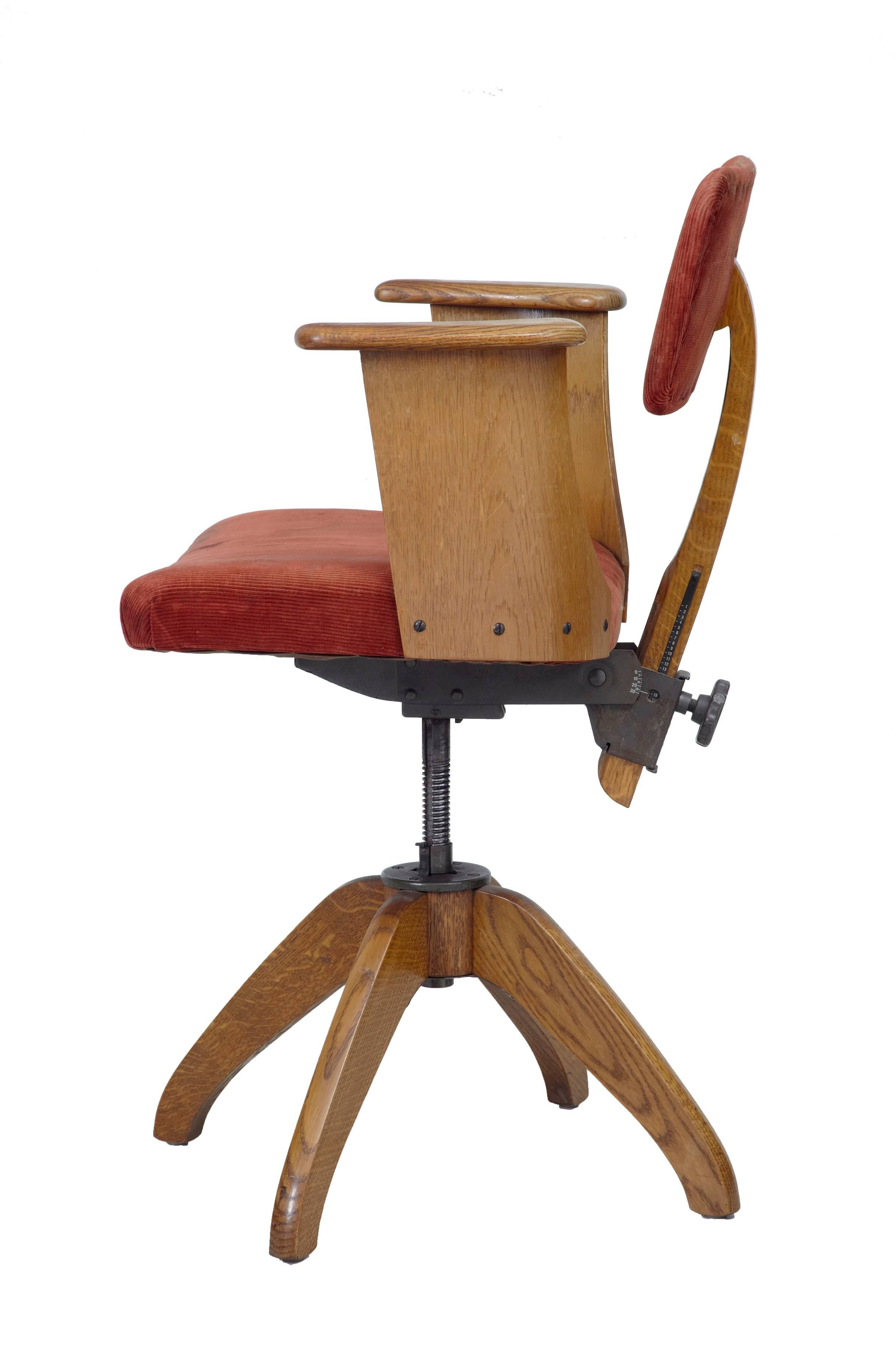 1920s oak adjustable office desk chair. Oak wrap round arms and four legged base. Red cordroy seat and backrest. Fully adjustable.
 
