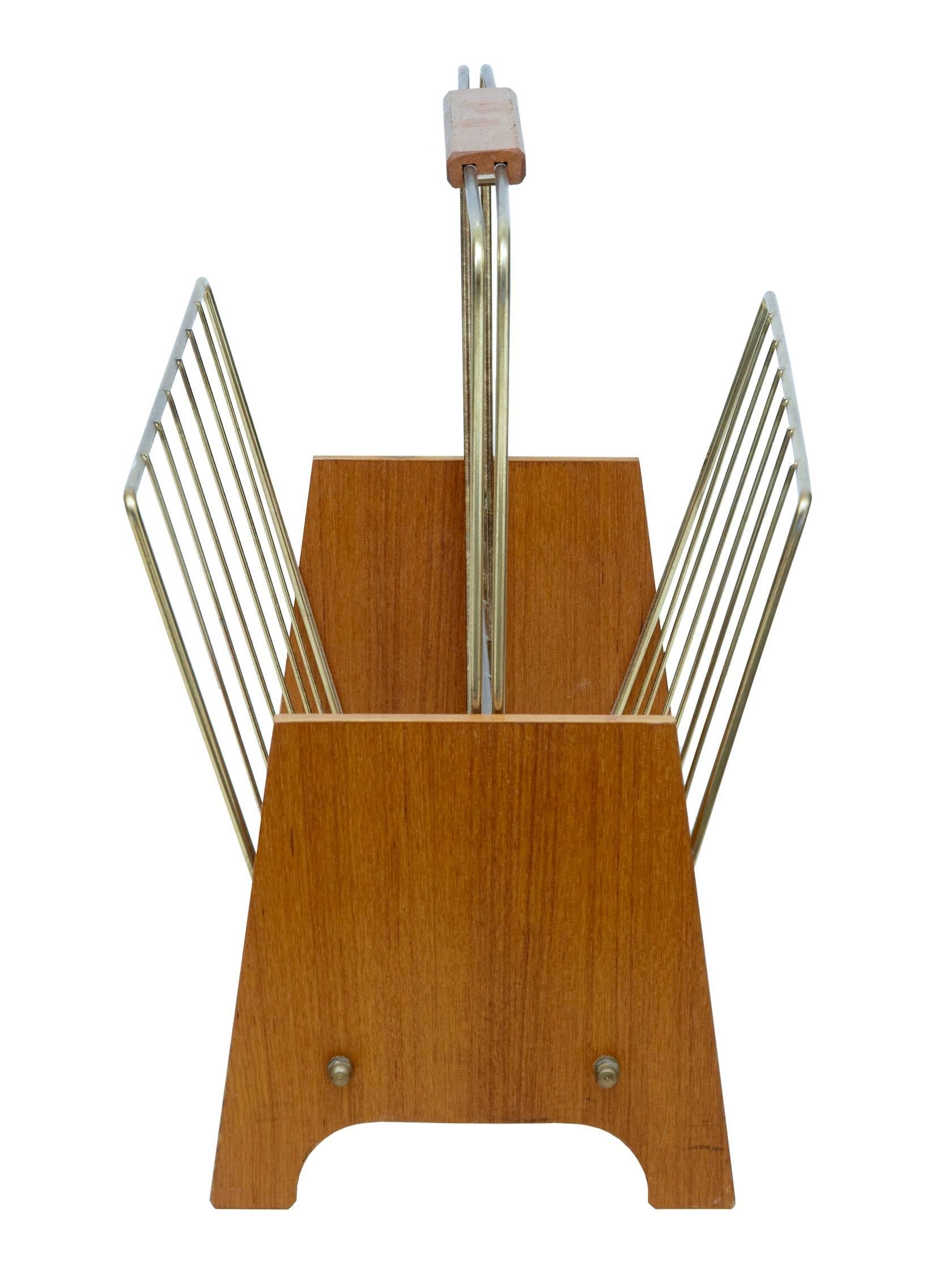 Scandinavian Modern 1960s magazine rack. Wooden teak handle with brass metalwork, standing between a pair of teak shaped ends.
 
Measures: Height 15 1/2