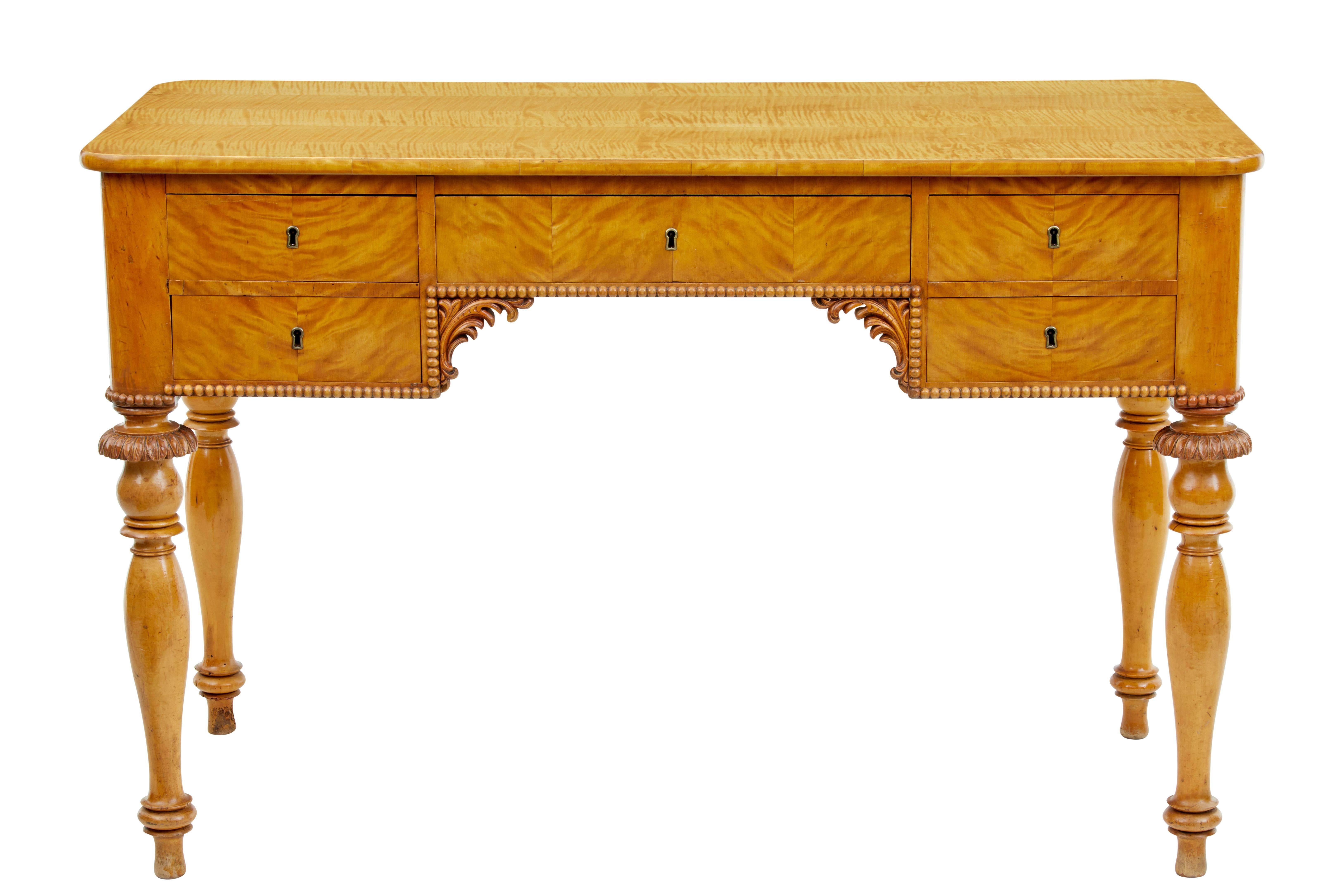 Good quality Swedish birch writing table, circa 1870.

Elegant table which would be perfect for a ladies writing table.

Five-drawers one of which is over the knee, beaded edging and applied swags in the knee hole.

Standing on four turned
