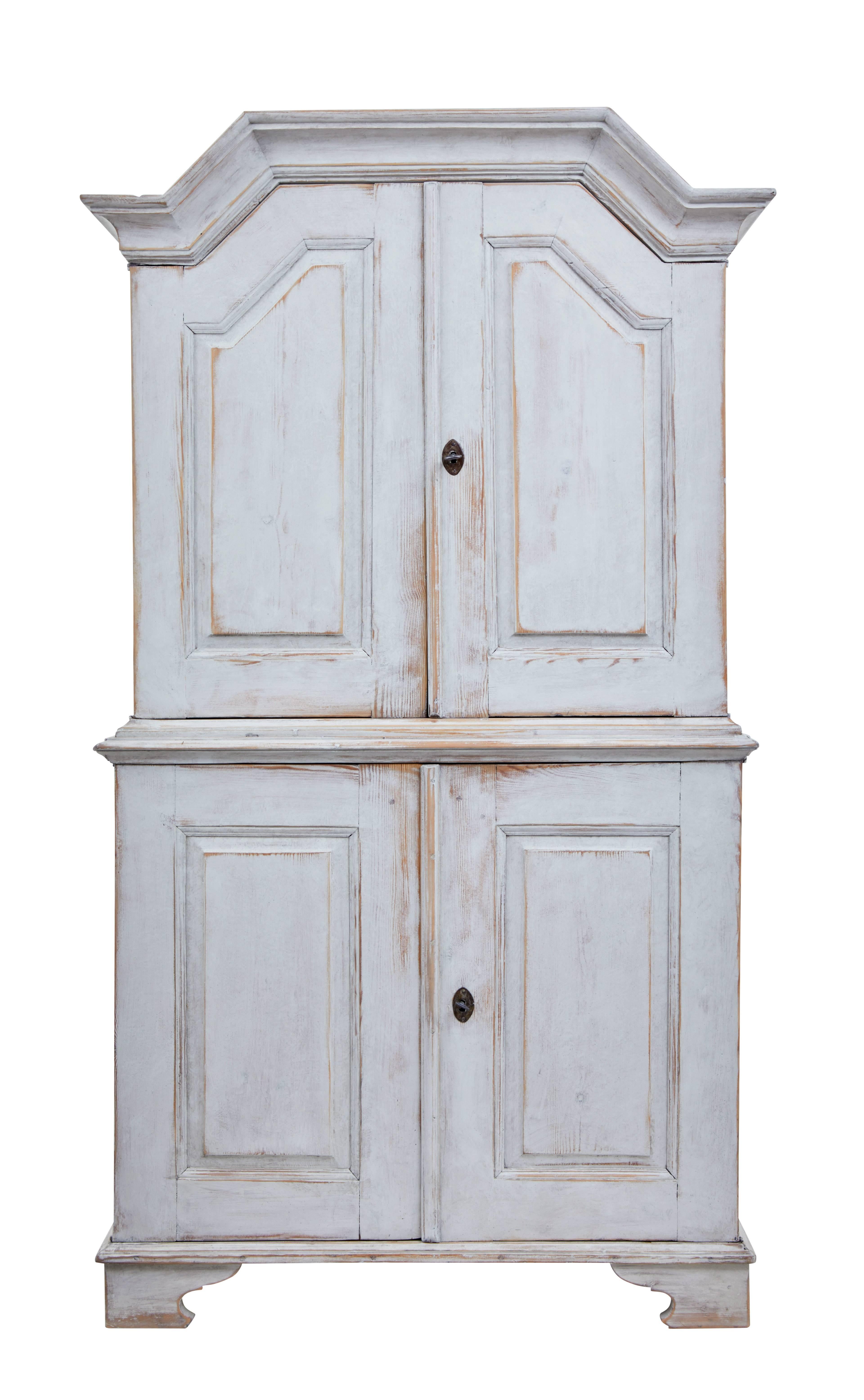 Beautiful two-part painted cupboard, circa 1860.

Later painted in grey with contrasting blue interior.

Top section with architectural pediment, fitted with two fixed shelves and a shallow storage rack. Bottom section with two fixed