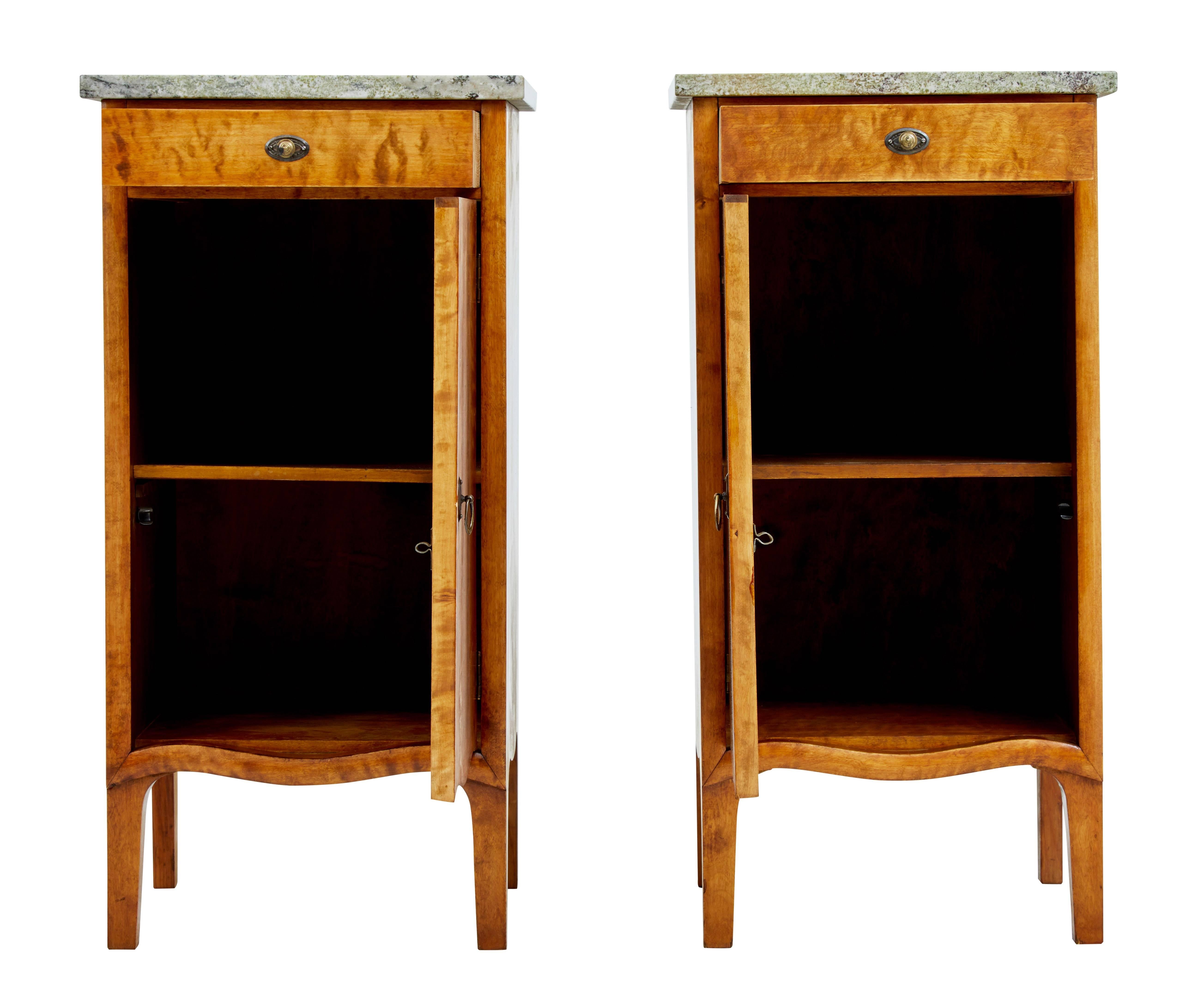 Pair of birch bedside cupboards, circa 1910.

With inlaid cartouche to the front door and slight curving to the legs, hint at a touch of Art Nouveau styling.

Single drawer to the top, with single door opening to a shelf. Granite marble tops