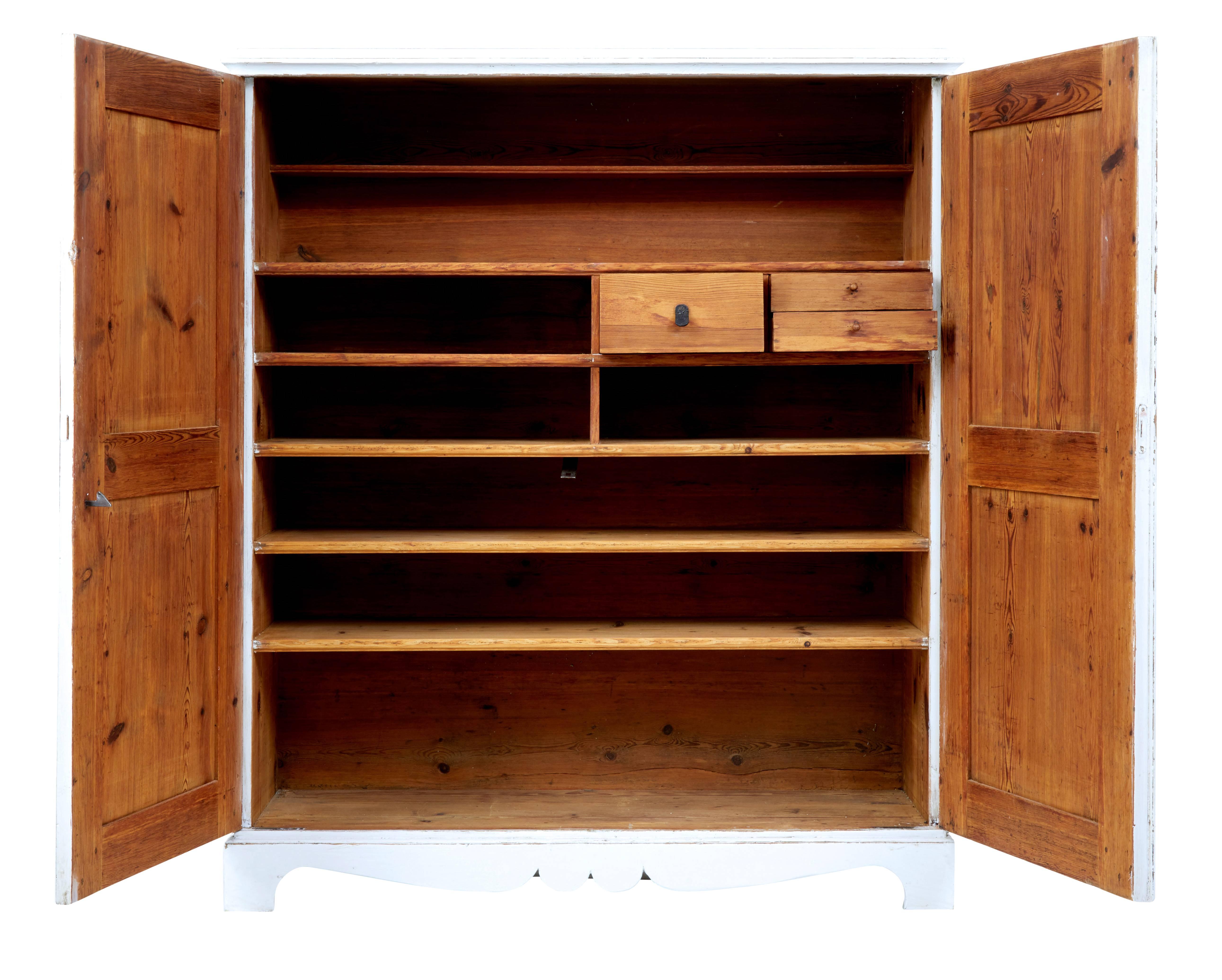 Swedish painted pine cupboard, circa 1870.

Double doors with recessed panels open to reveal a partially fitted interior.

Four shelves and four compartments, one compartment fitted with three shelves. Practical for use as a linen cupboard or in