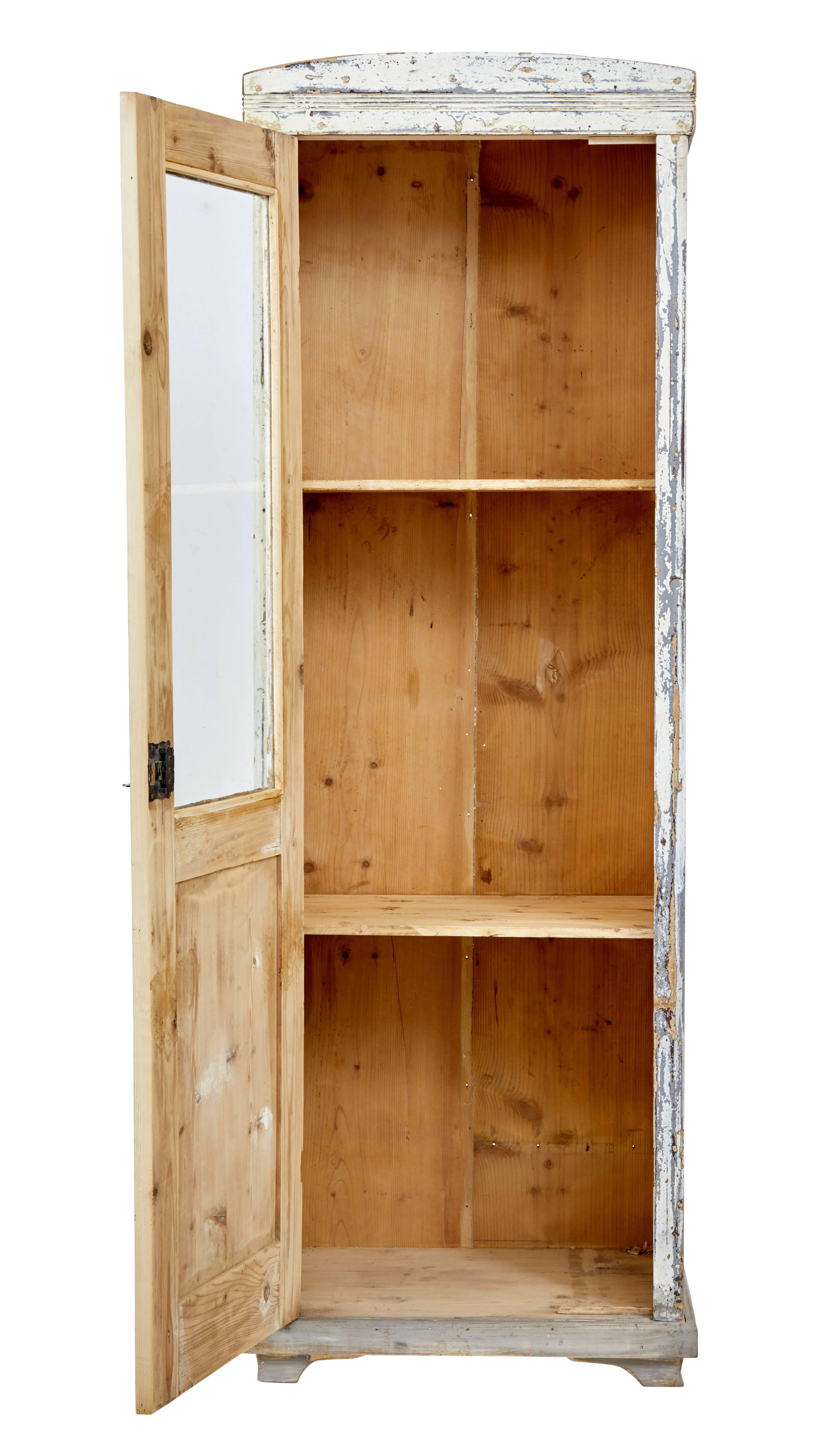 Rustic Swedish pine cabinet, circa 1890.

Presented in original scraped back paint.

Single half glazed door opens to an interior of two shelves. Ideal for a linen or kitchen cupboard.

Replaced feet and moulding.

Obvious paint losses and