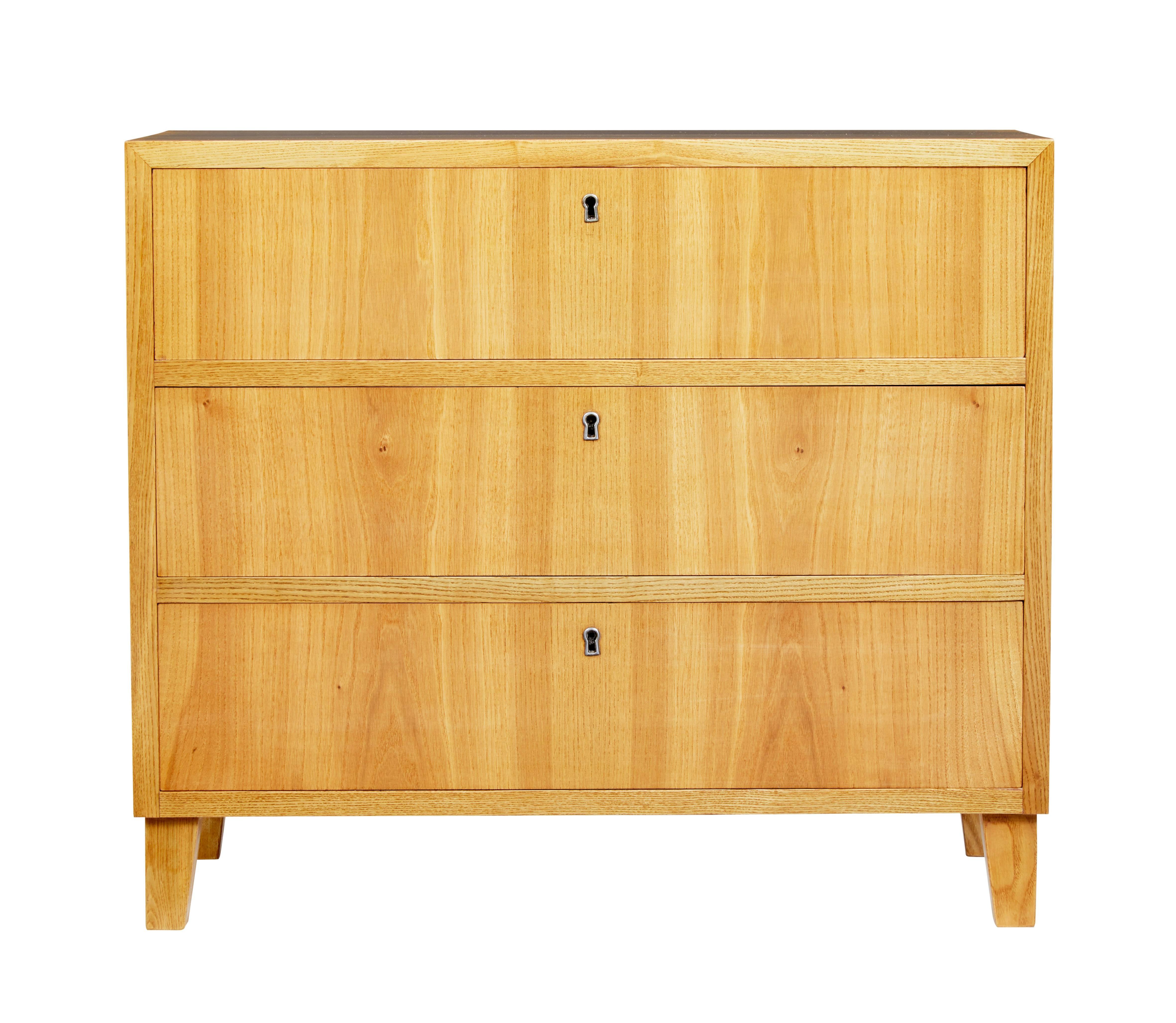 Elegant chest of drawers of small proportions, circa 1950.

Three drawers which open on the key. Lovely light color. Standing on tapered legs.

One very light scratch to side which has been polished over.