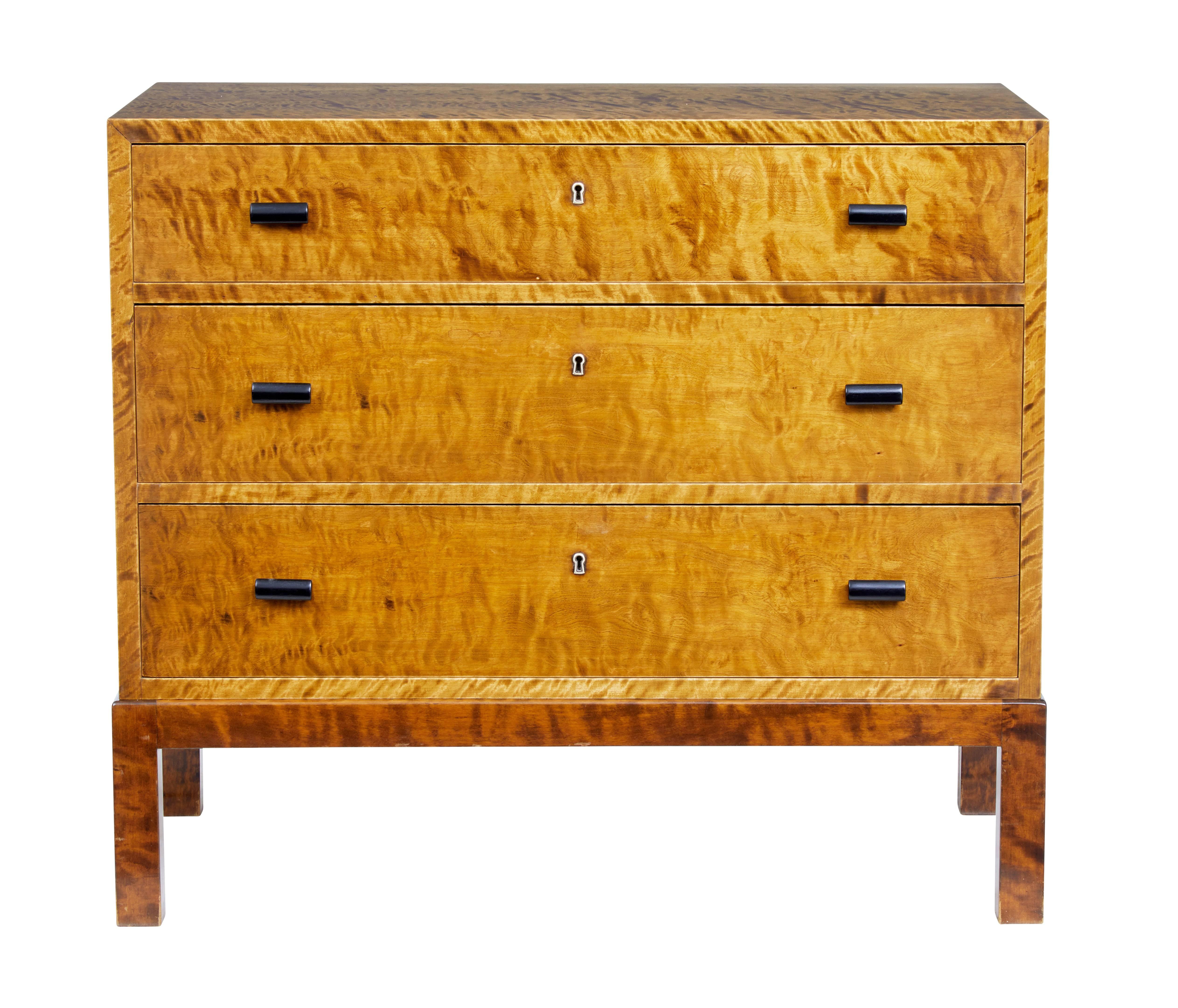 Fine quality Art Deco inspired Swedish chest of drawers, circa 1960.

Made from quarter sawn birch veneers which gives it this tiger like appearance.
Three drawers with ebonised handles.

Rich golden colour.
 