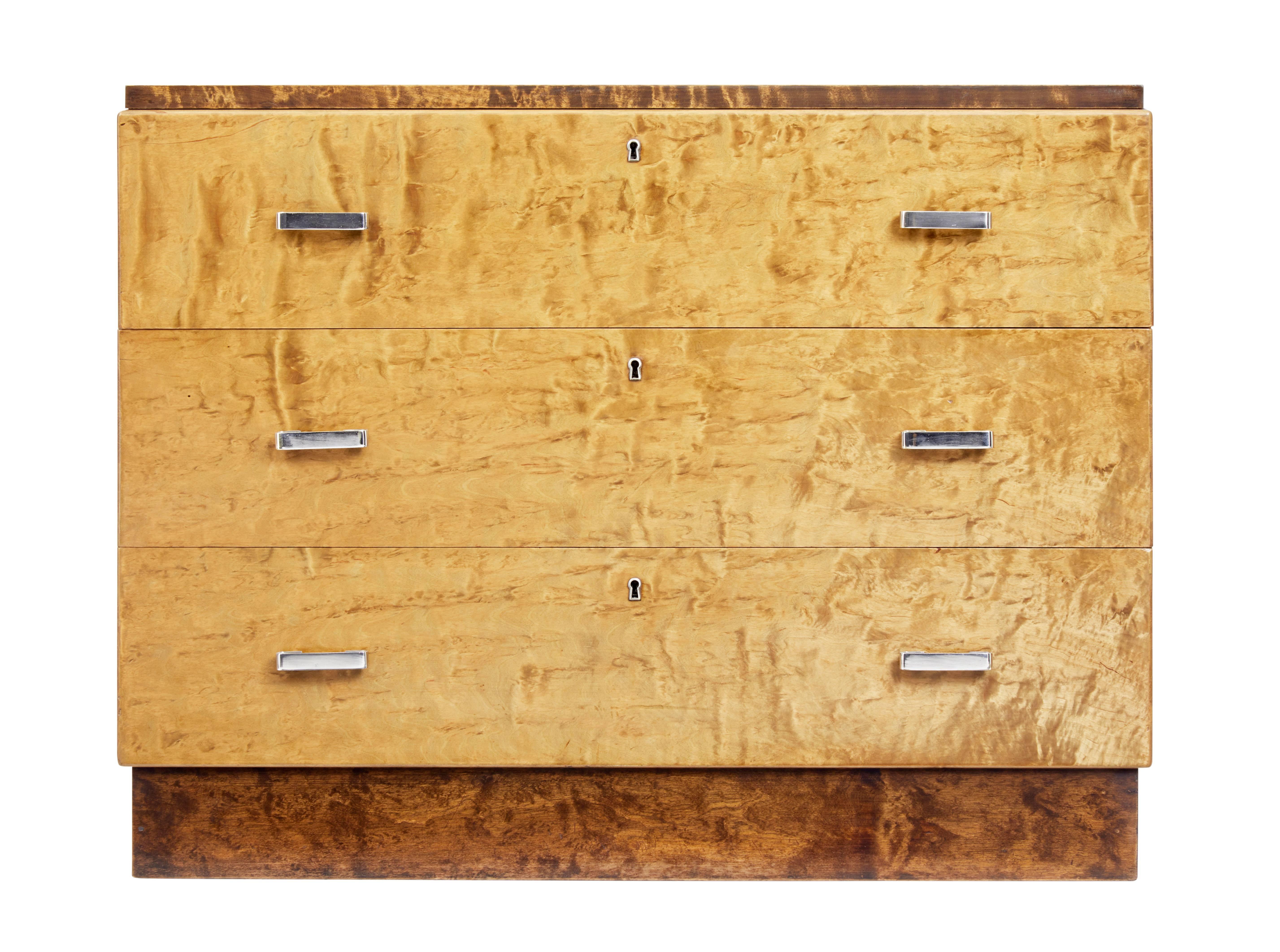 Art deco period chest of drawers, circa 1930.

Two-tone burr birch effect, with the darker top and plinth contrasting with the main body.

Three drawers with original polished steel handles.