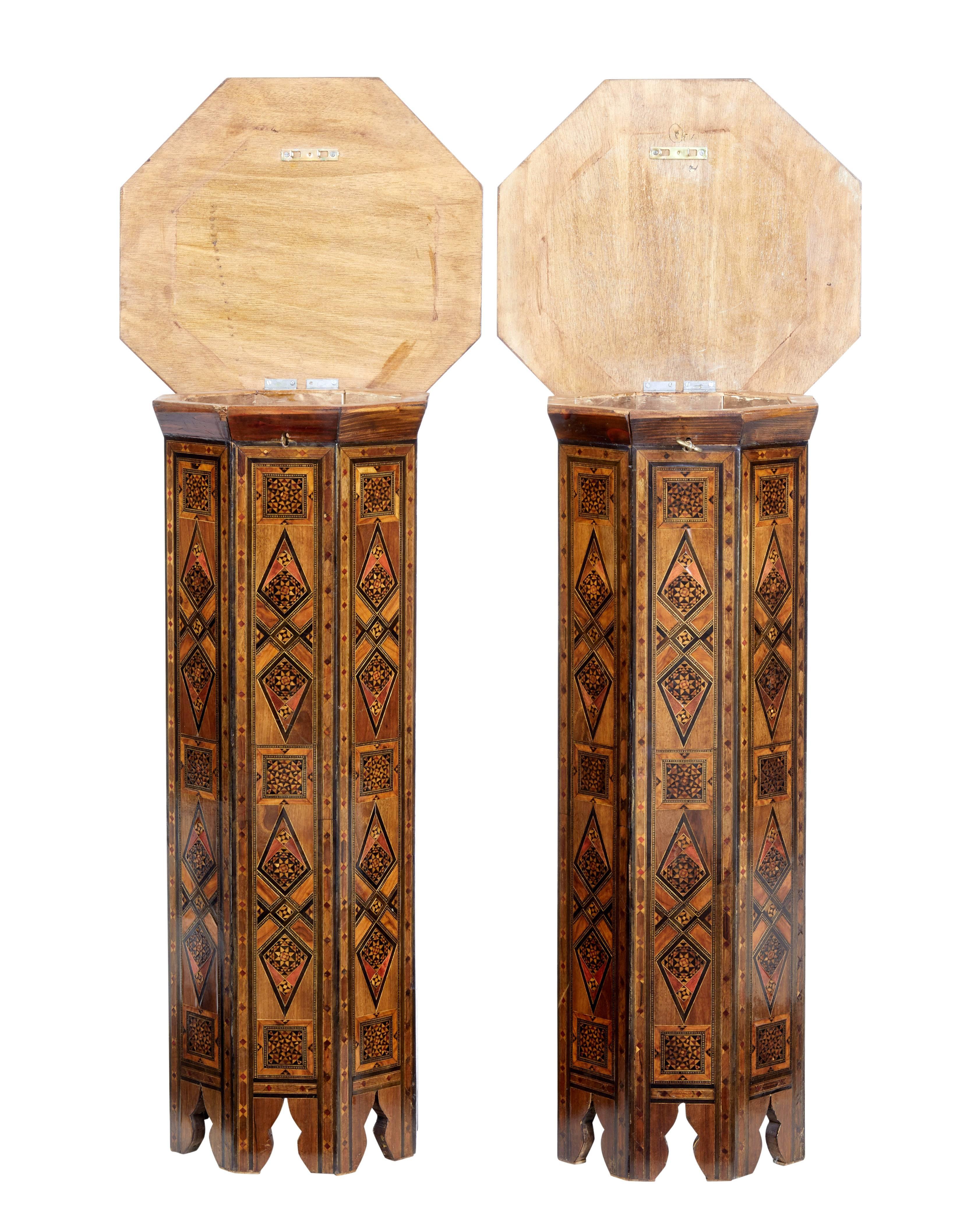 Pair of profusely inlaid Damascan pedestals, circa 1920.

Later converted with hinged tops to allow storage inside. Lids lock with key.

Octagonal top inlaid with various exotic woods and mother-of-pearl.

Surface marks and minor losses.