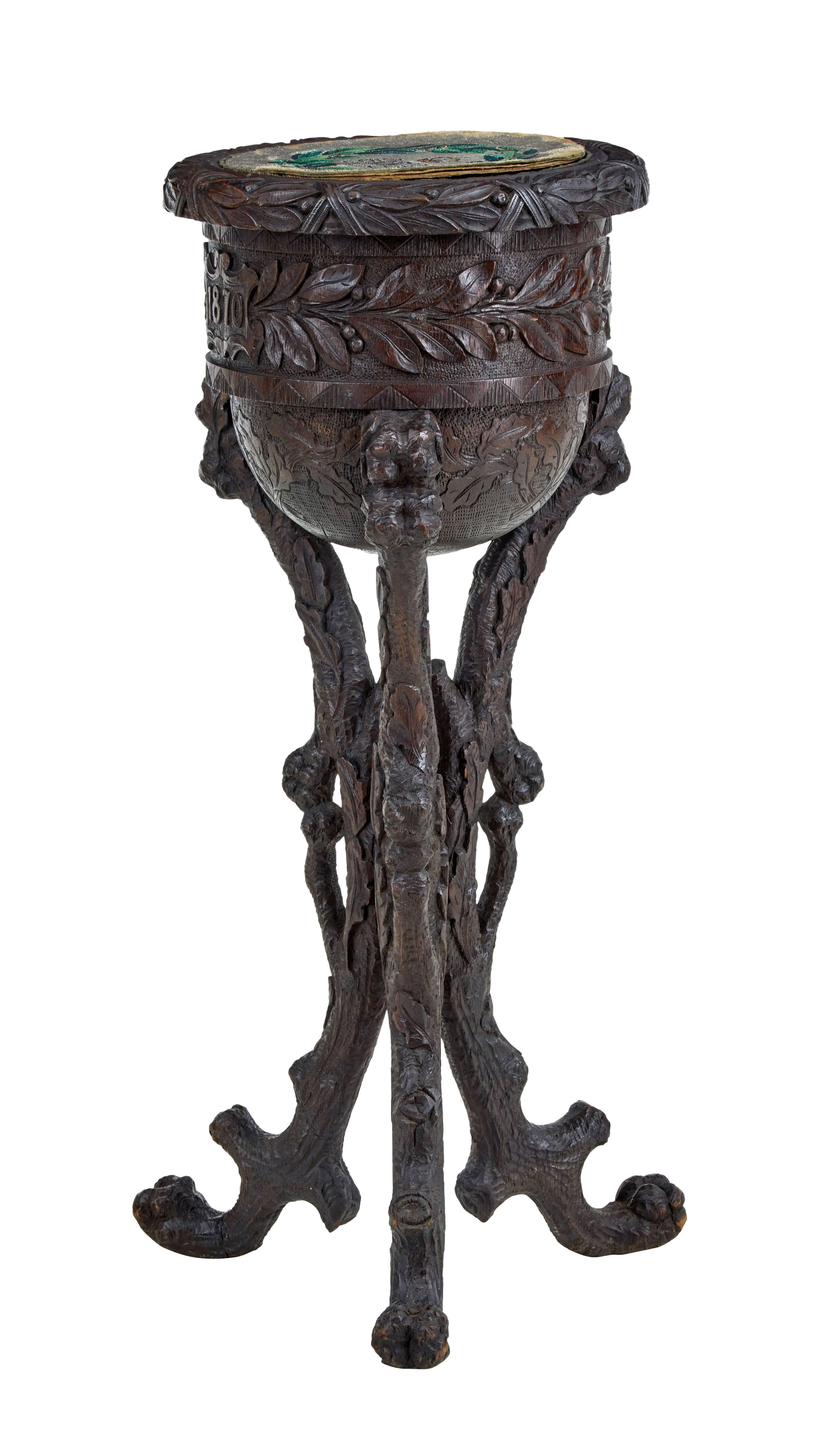 Unusual profusely carved stand dated 1870.

We can't quite put our finger on what this piece actually is, obviously some type of caddy.

Original dated tapestry on the lid, finely carved with leaves and foliage and dated again on the