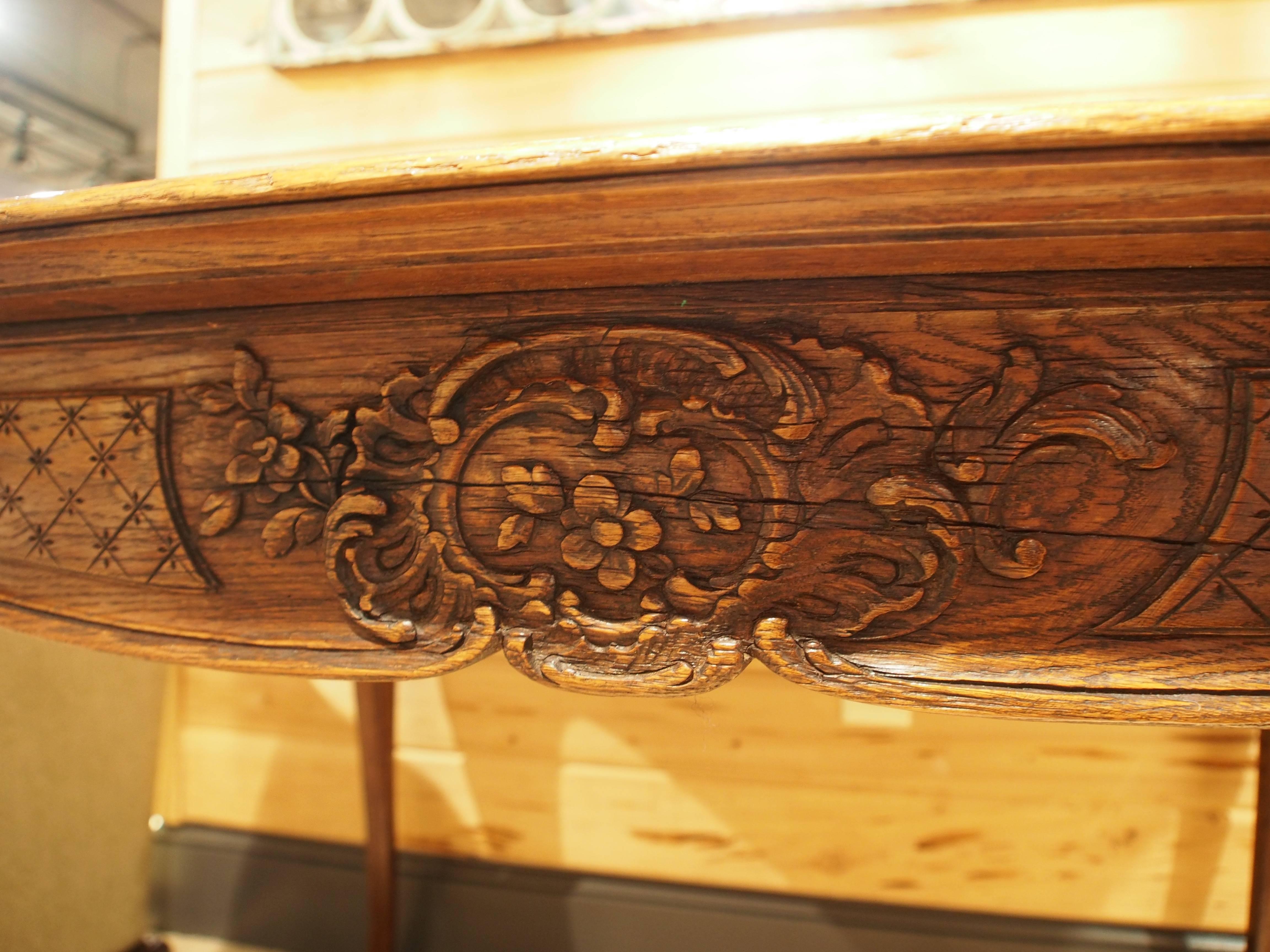 Oak table with ornate carved apron and cabriole legs with hoof feet.