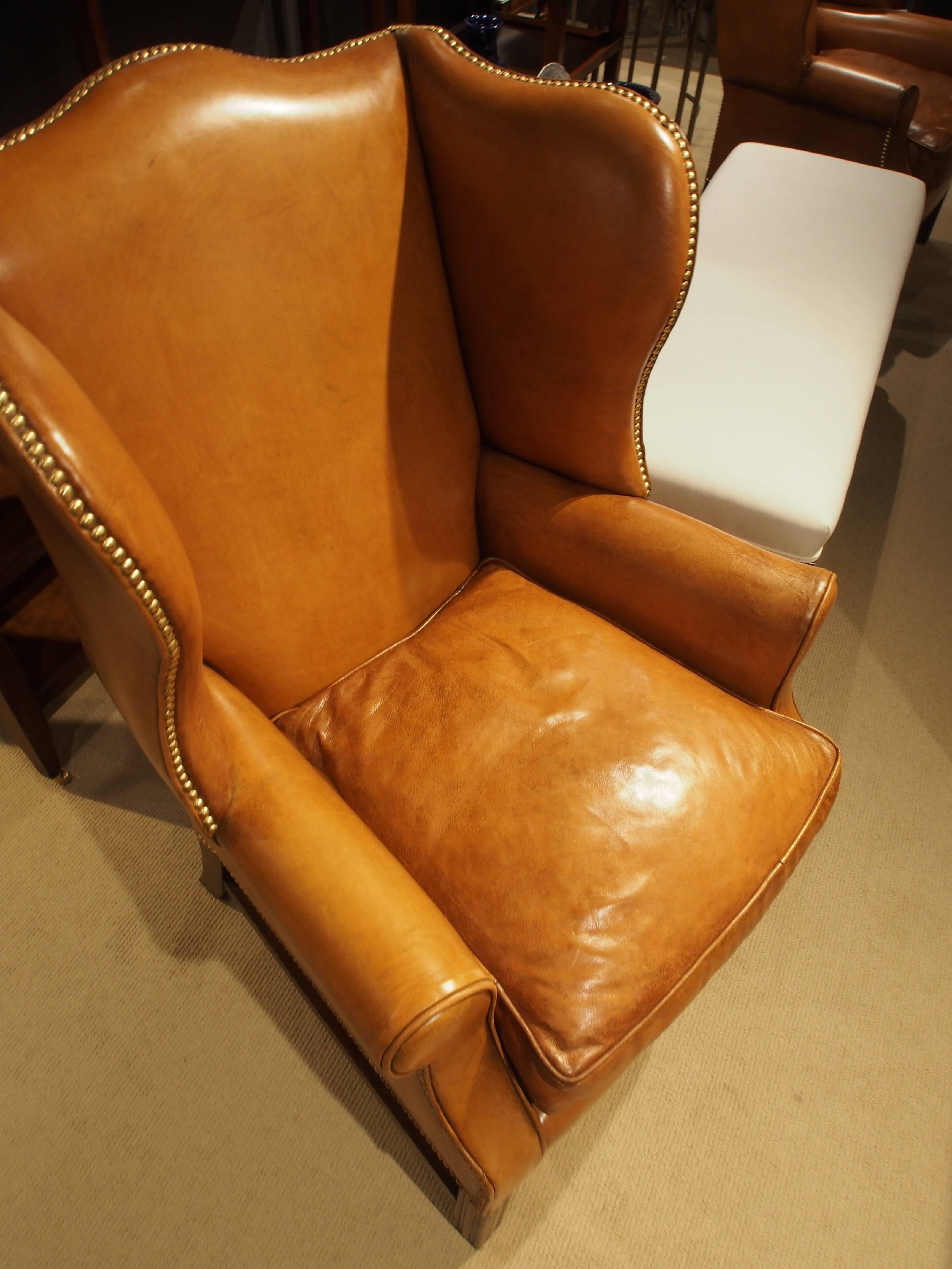 Sudbury wing chair in light tan leather with brass nailheads.