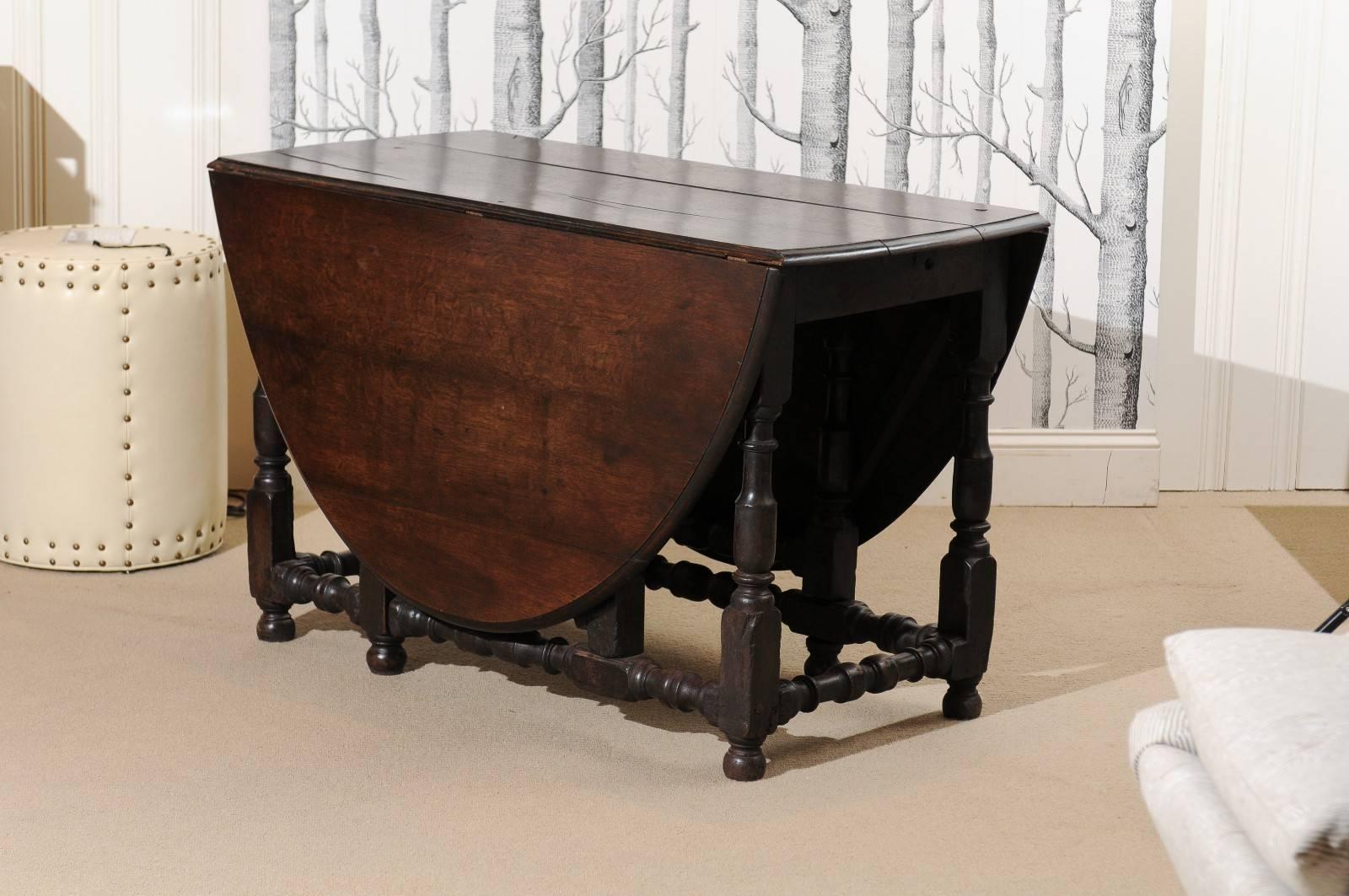 English gate leg table with carved legs and dark finish.