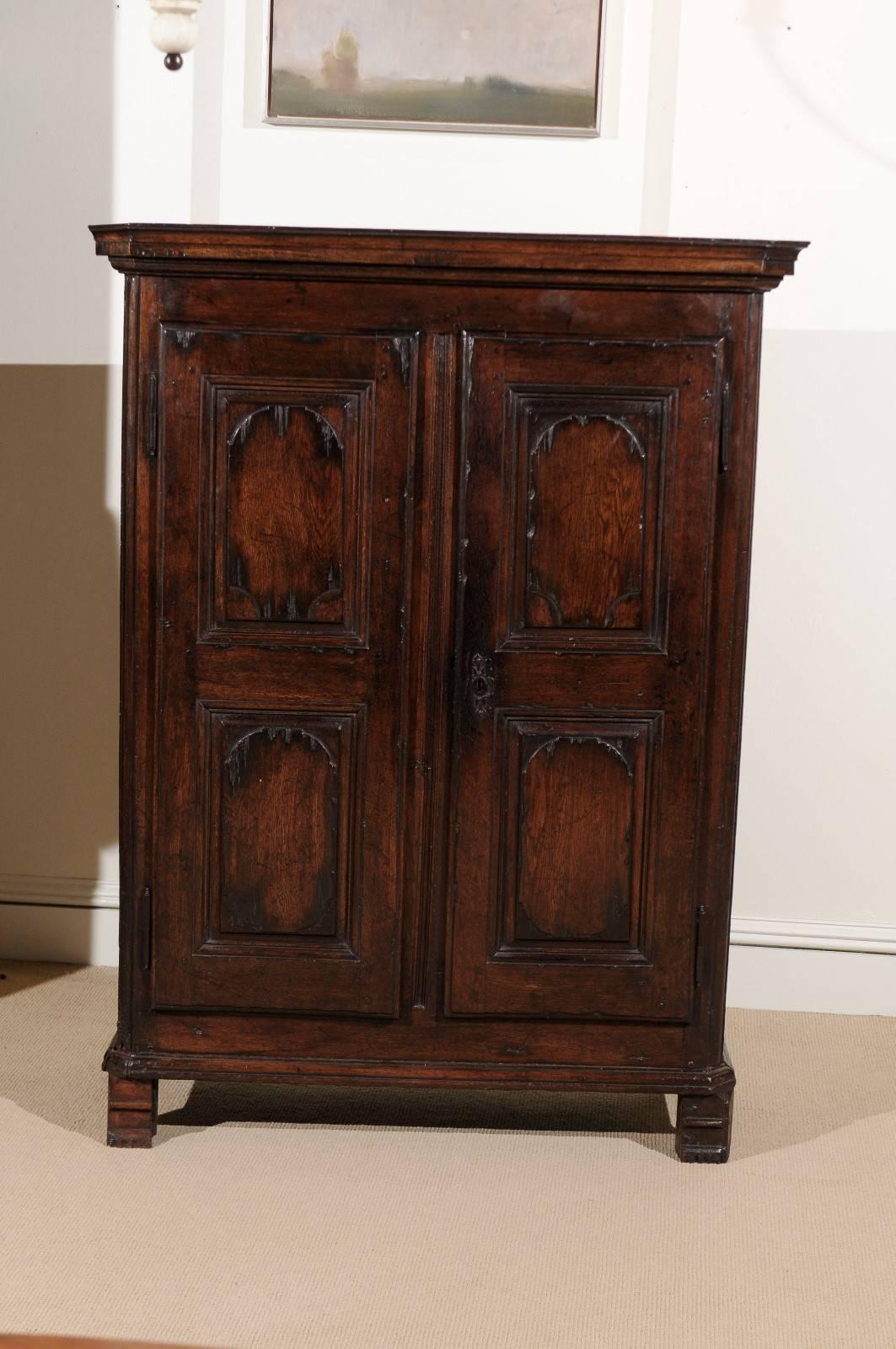 Armoire in oak, circa 1800 with carved doors and two interior shelves.