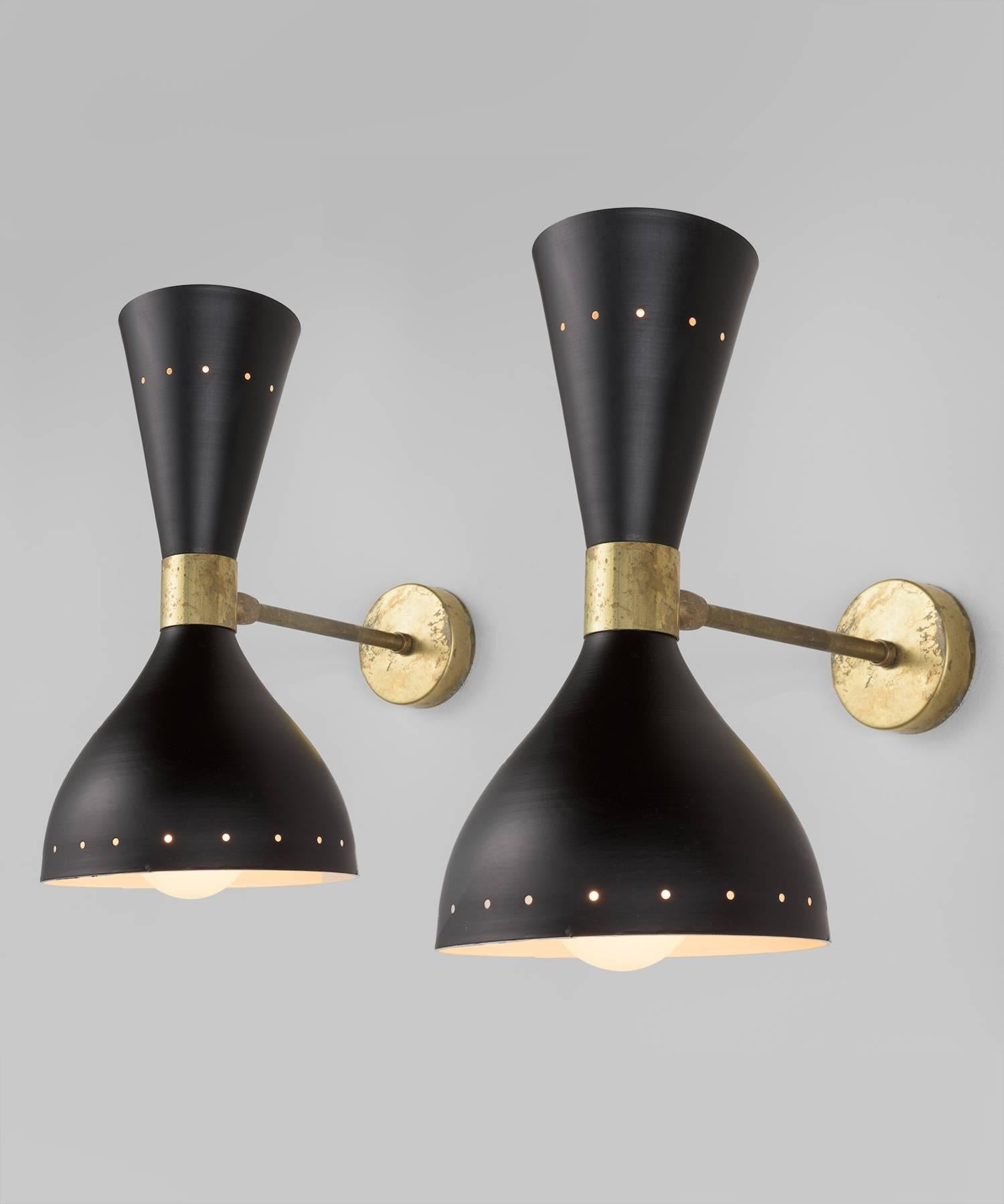 Black metal and brass modern sconce, circa 1960.

Perforated black lacquered shade, with articulating polished brass arm.