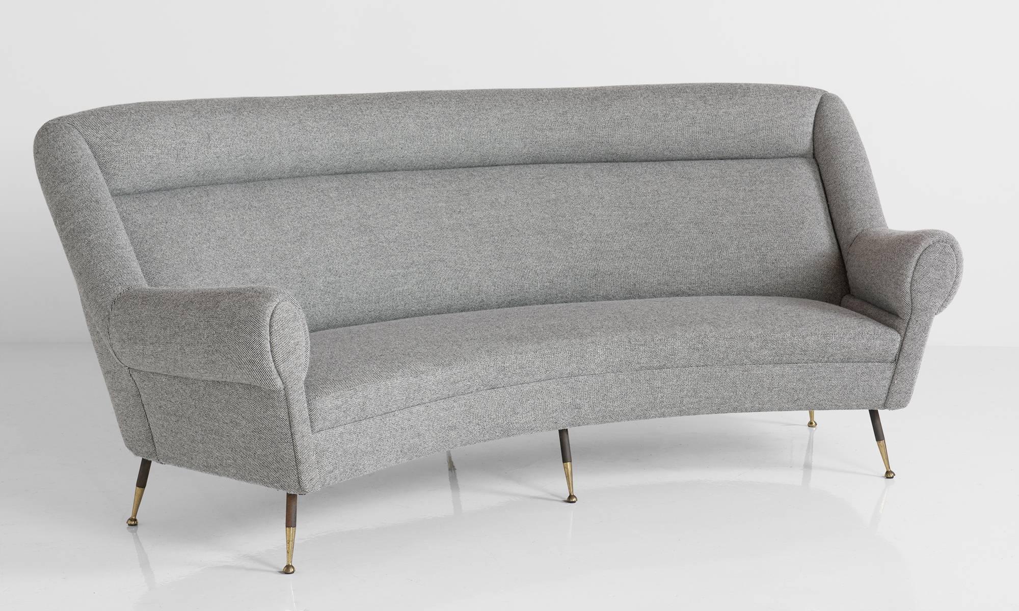 Wool and brass modern curved sofa, circa 1960.

With black metal and brass feet. Newly reupholstered in Maharam wool fabric.