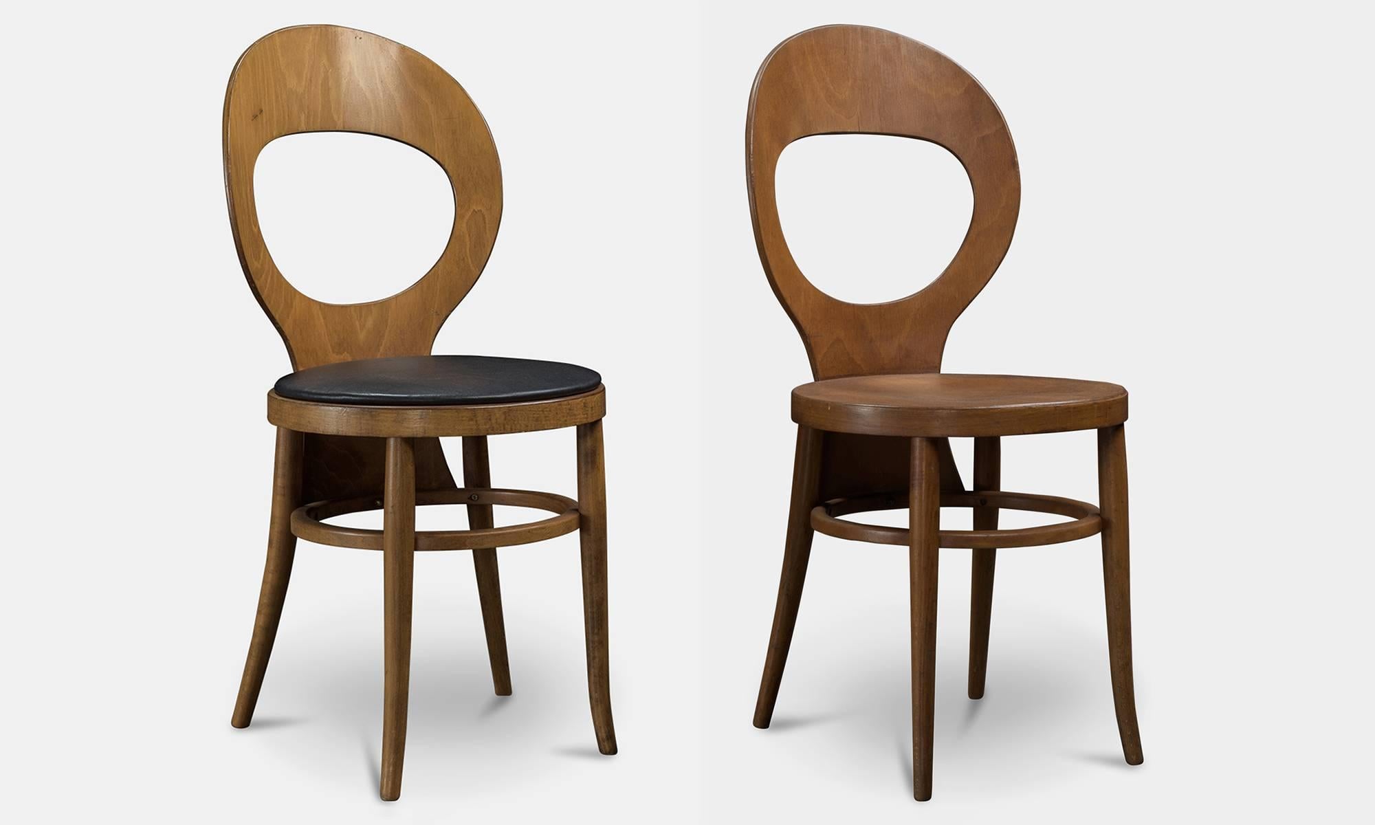 Bentwood dining chairs, one with black upholstered seat and one without.