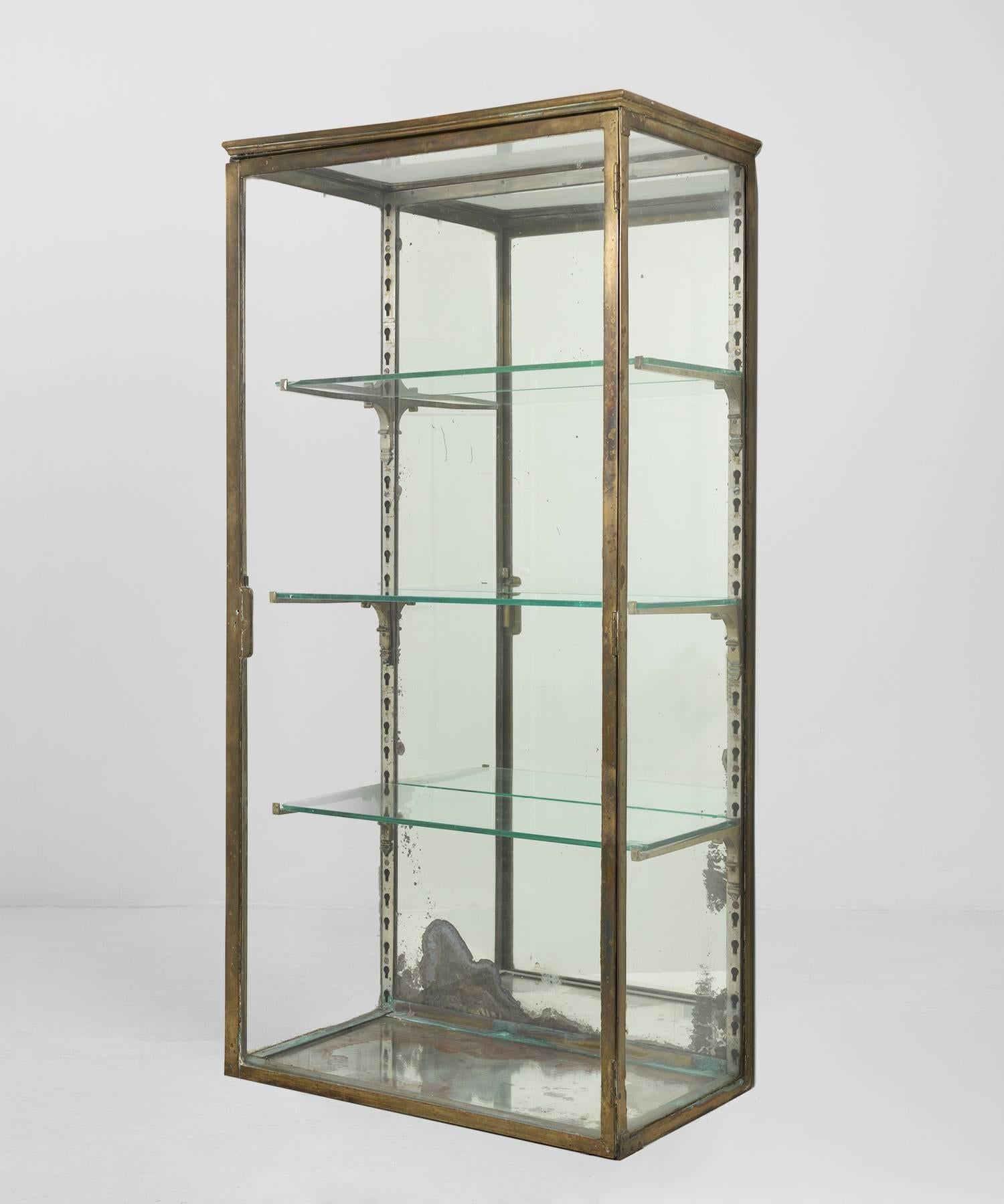 Brass and mercury glass display cabinet, circa 1900.

Elegant wall display cabinet with mirrored back and three glass shelves.