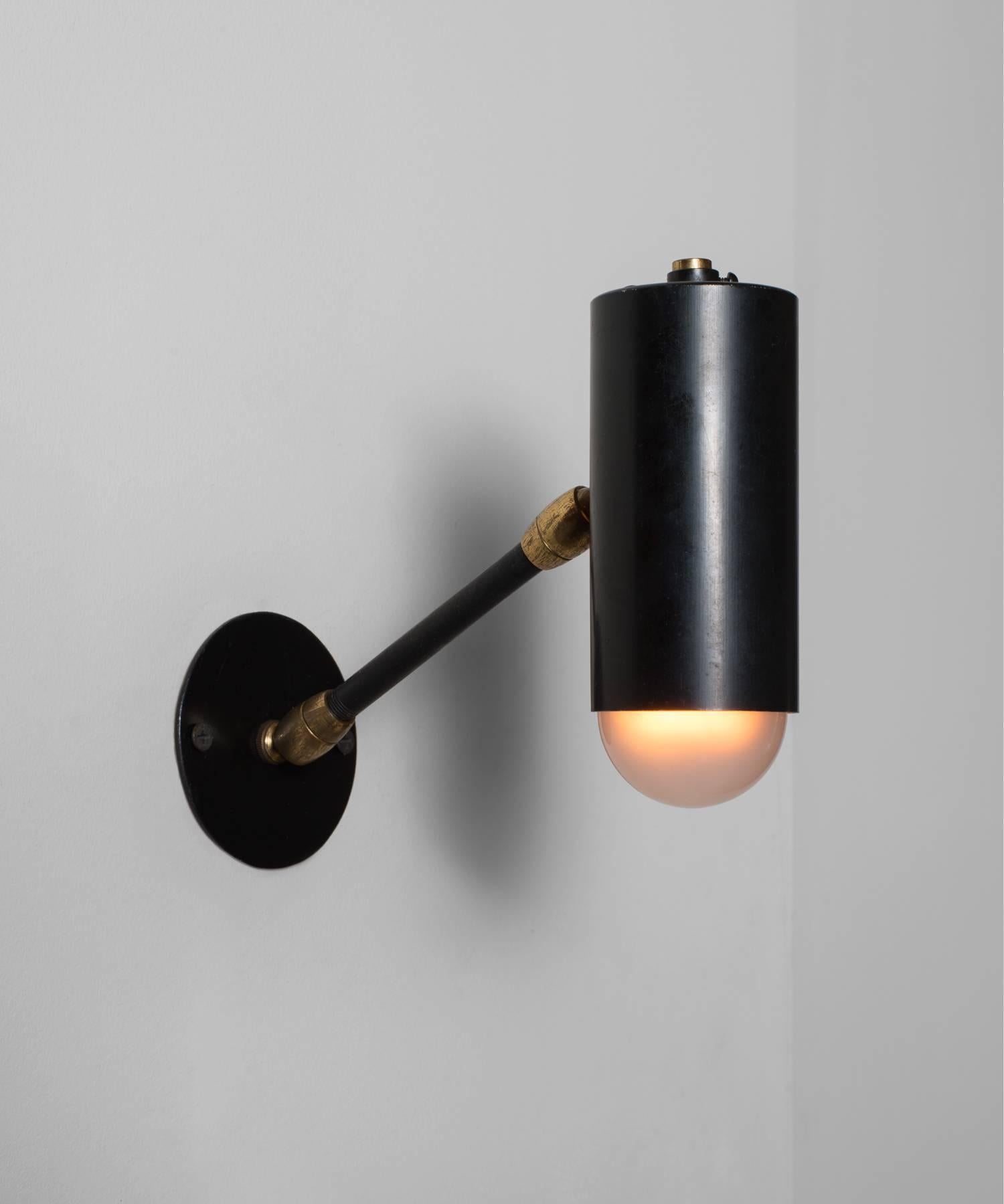 Black metal and brass petite modern sconce, circa 1950.

Metal construction with brass hardware and adjustable arm.