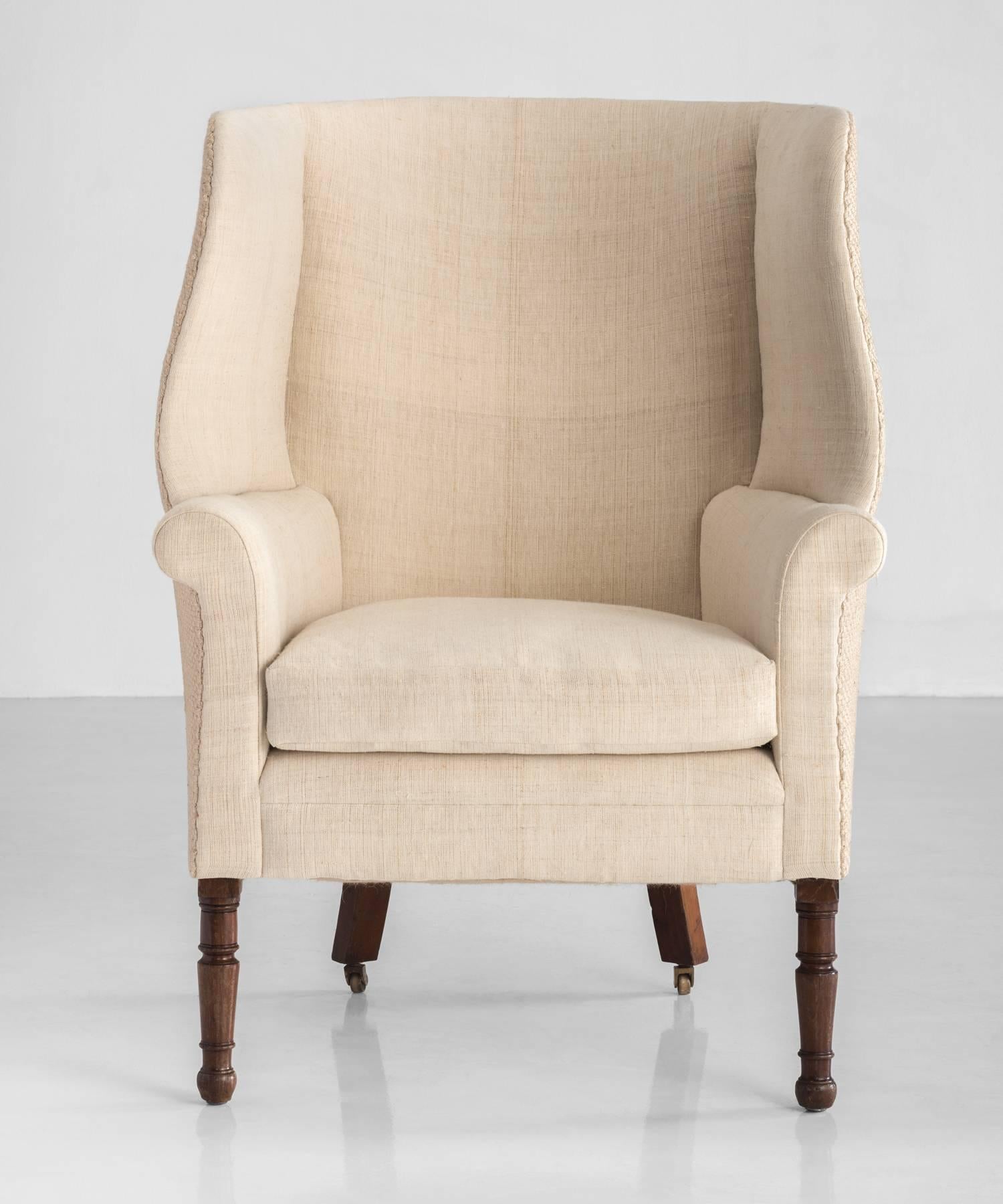 Regency Barrel back wing chair, circa 1830.

Newly reupholstered with linen interiors and burlap exterior, on turned legs.
