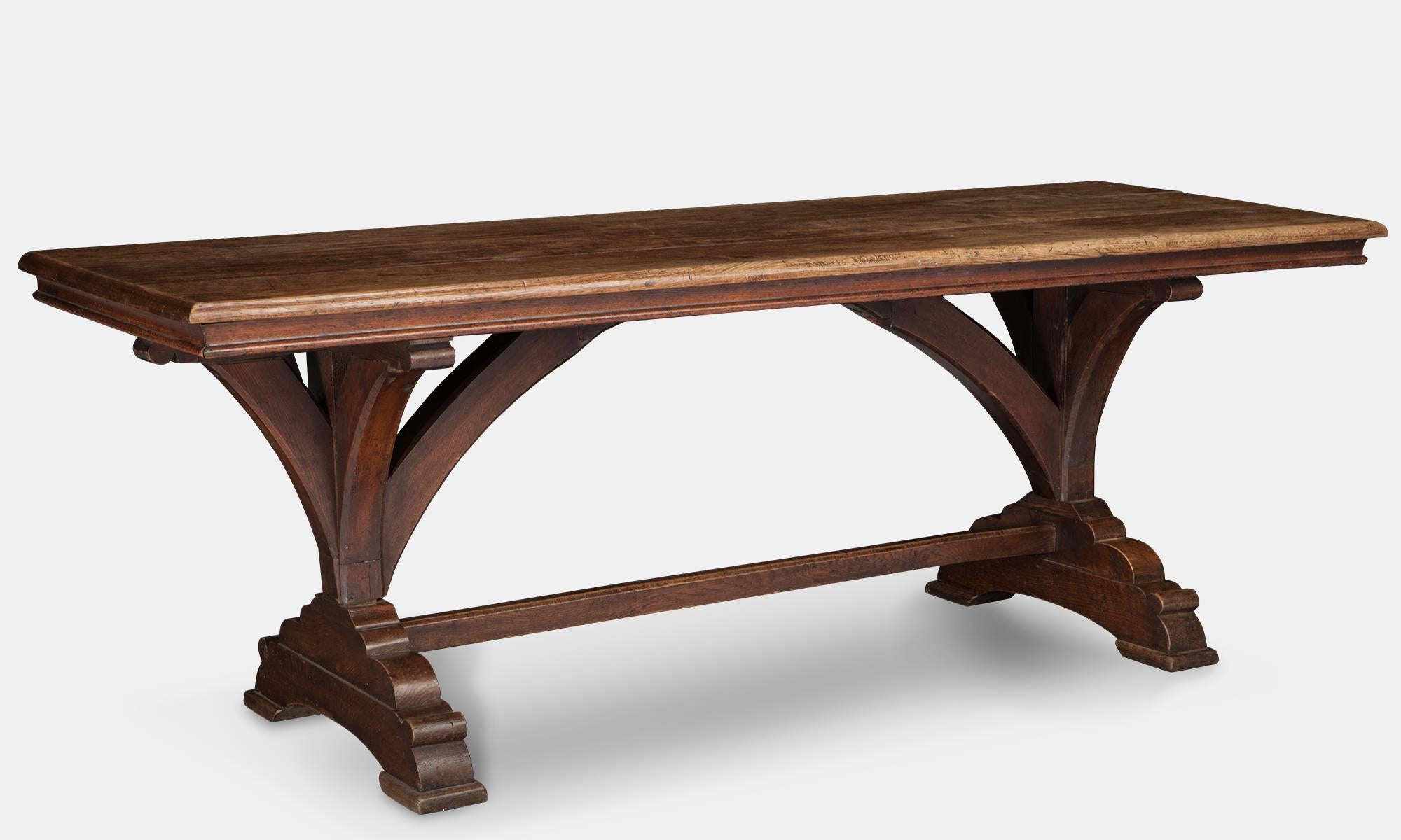 Oak three plank top raised on arched supports on trestle legs. In the manner of A.W.N. Pugin.