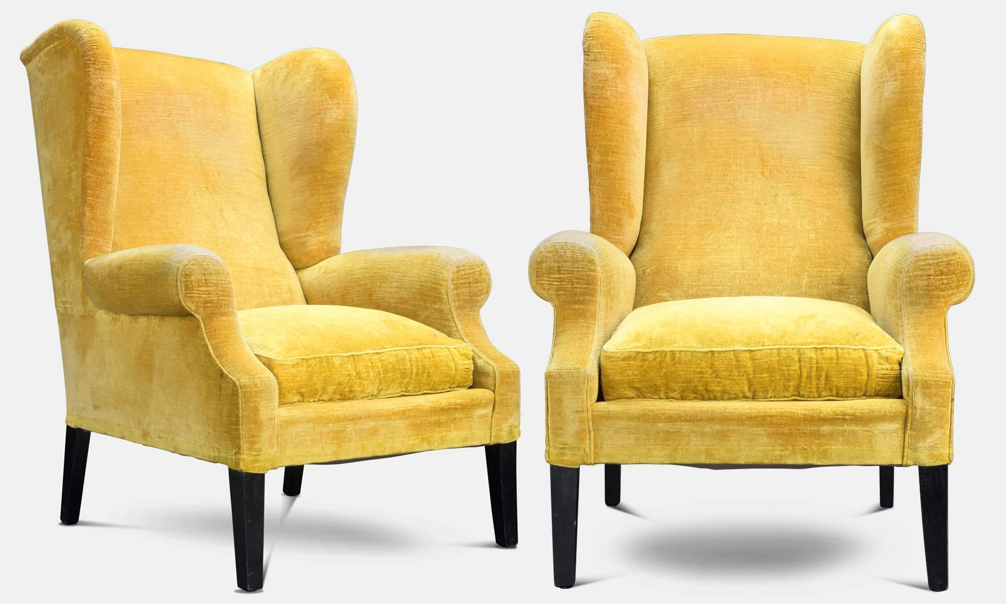 Pair of yellow velvet wingback armchairs, circa 1950.

Beautifully worn, original vibrant yellow upholstery with ebonized wooden legs.

   