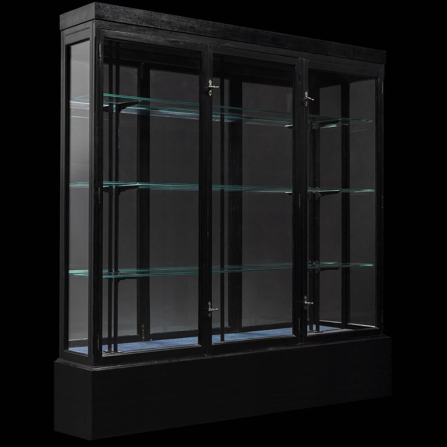 Ebonized Wood and Glass Display Cabinet, England, circa 1920

Thin wall cabinet with glass shelves and original brass hardware. Three doors in front.
 