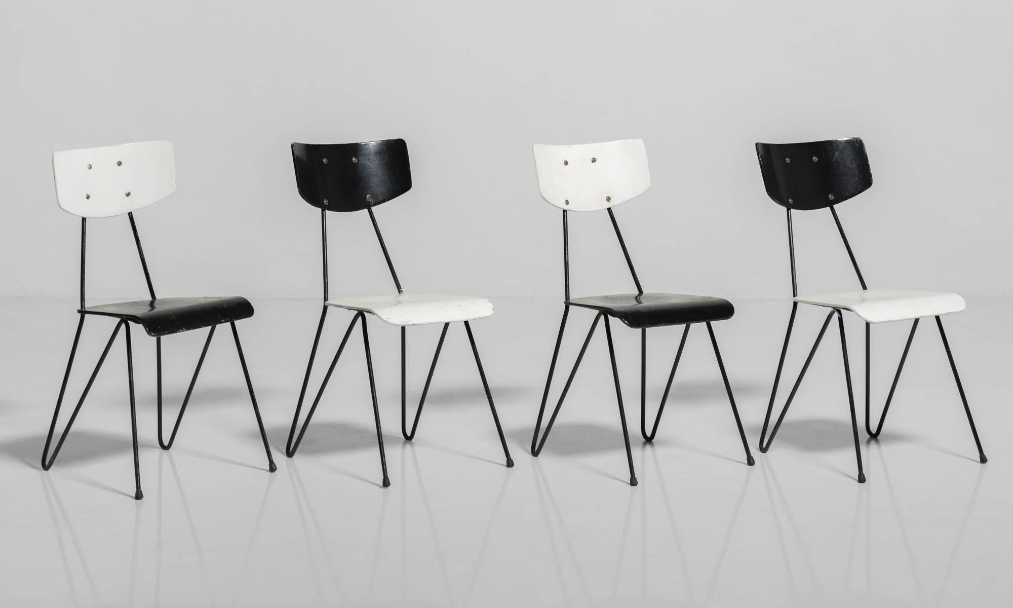 Modernist wood and metal side chairs, circa 1950.

Alternating painted black / white wooden seats and backs on black metal base.