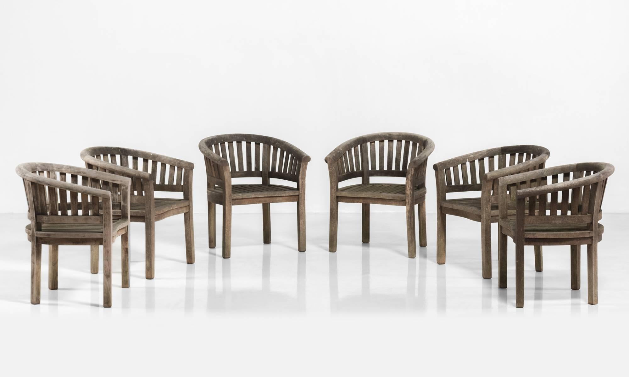 Teak garden chairs, circa 1950.

Curved hardwood chairs with slatted seats and back.