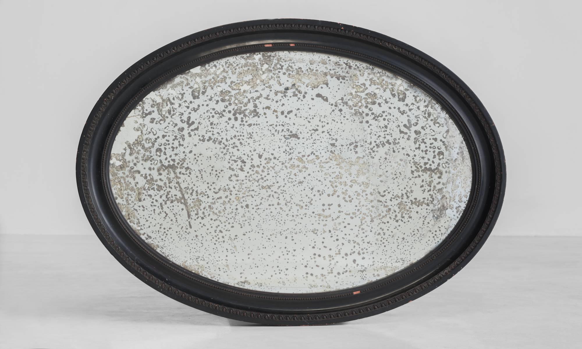 Victorian oval mirror, circa 1880.

Original bevelled edged mirror plate, with beautiful foxing, in moulded ebonized border frame.