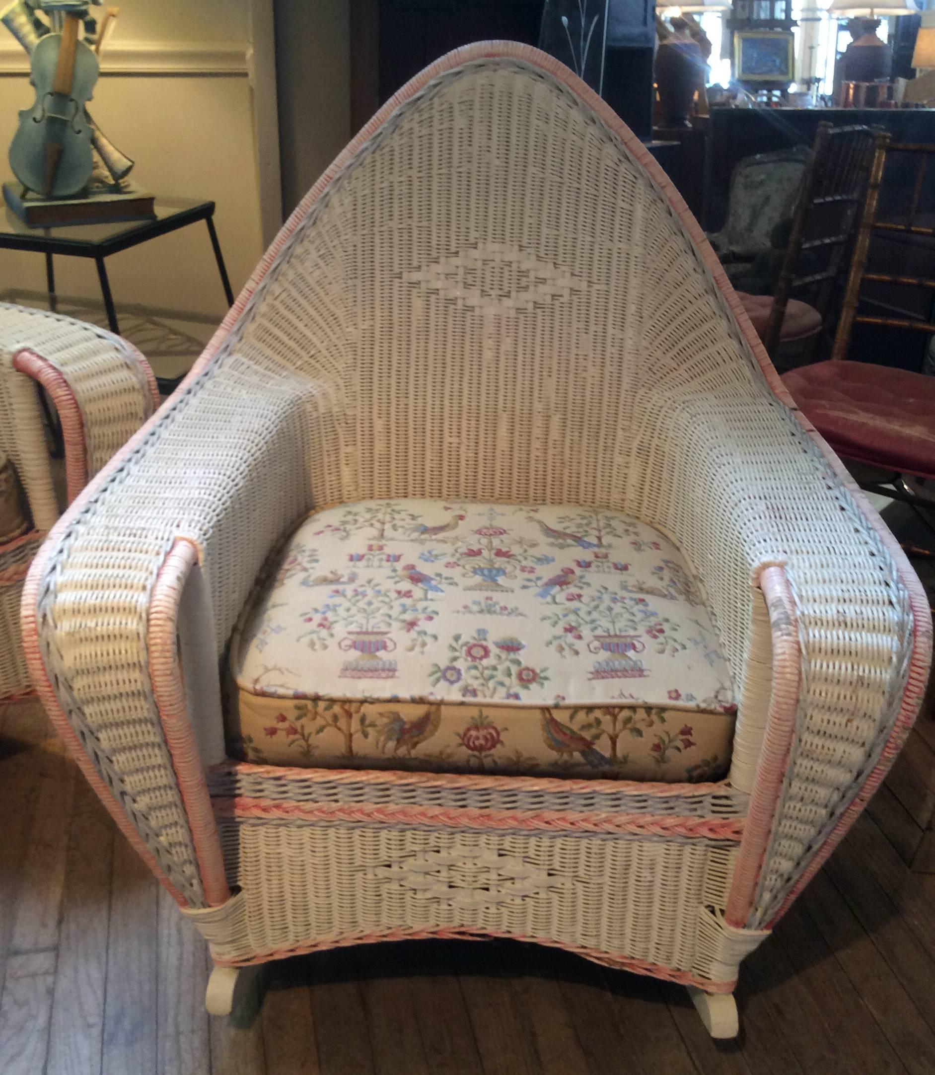 A very charming antique 1930s woven wicker lounge group, includes a three-seat sofa and a pair of matching rocking lounge chairs. All in their original painted ivory finish, with faded trim of pale pink and blue. Excellent condition, with original