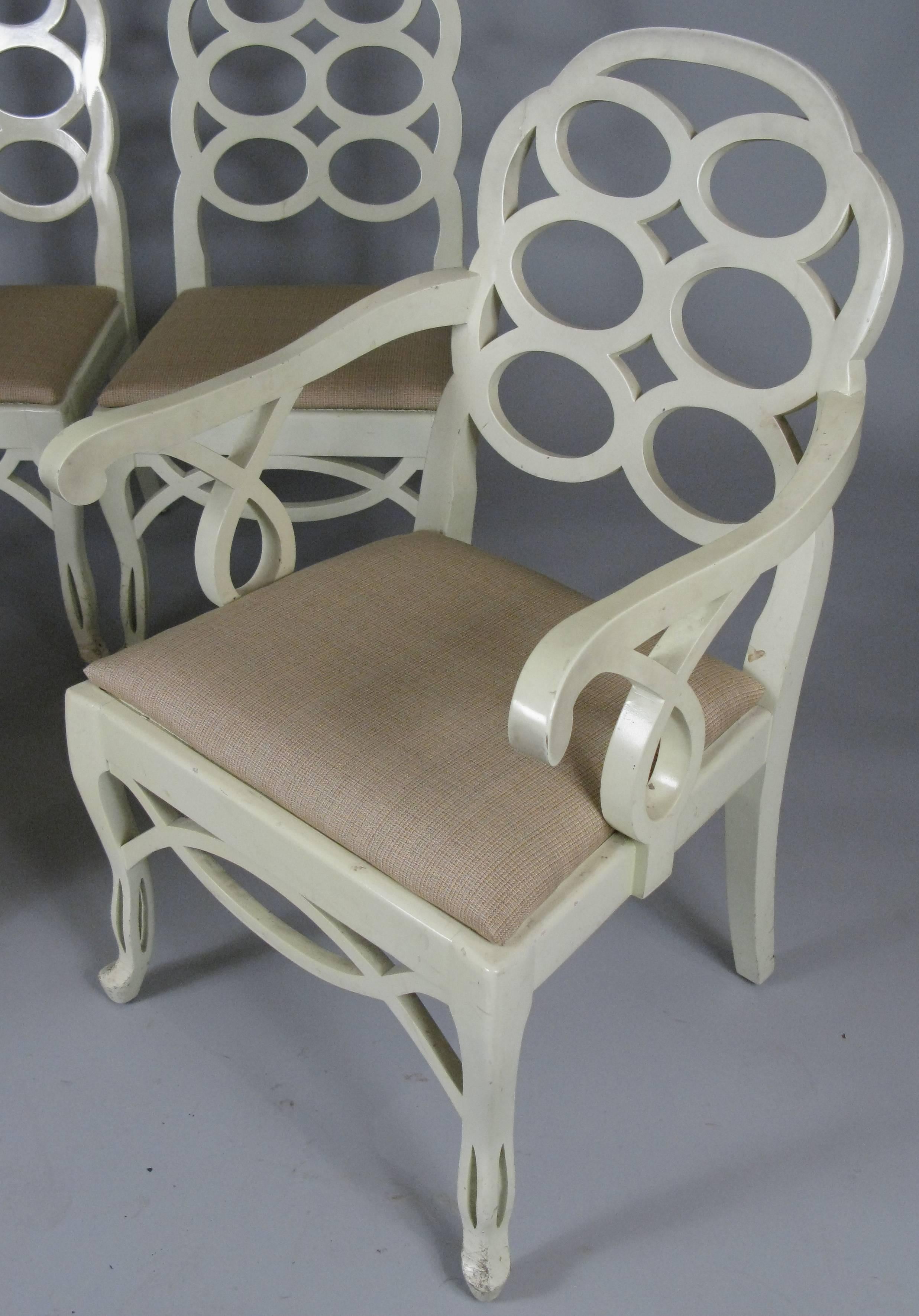 A matched set of four of Frances Elkins iconic Loop dining chairs, with a pair of armchairs and a pair of side chairs. All with the original caned seat under an upholstered seat cover. The original ivory lacquer finish is in fair condition, with