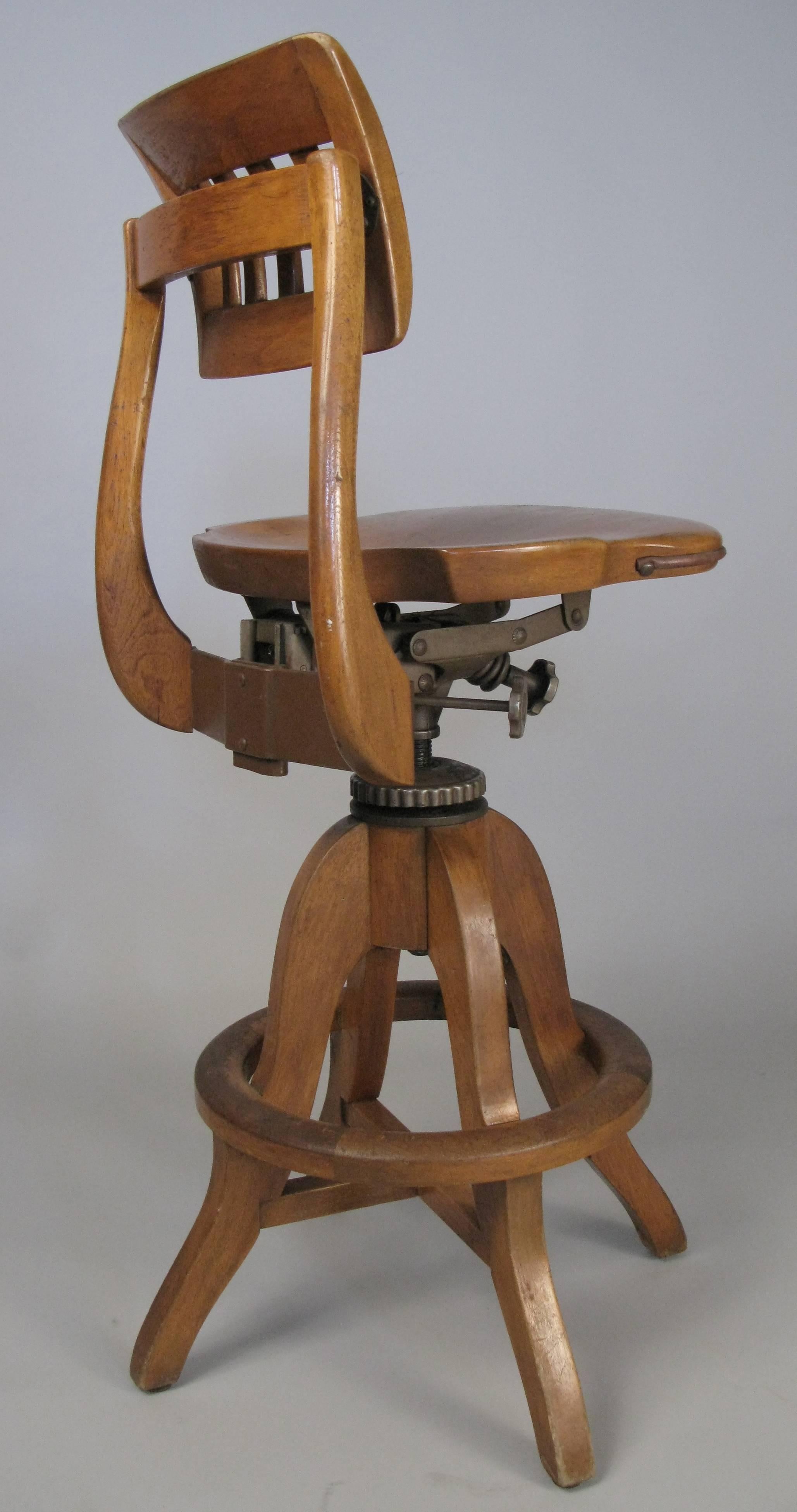 An antique drafting stool with circular footrest by Sikes, circa 1920, with an adjustable height seat, and back with adjustments for height and angle. Beautiful details and patina.