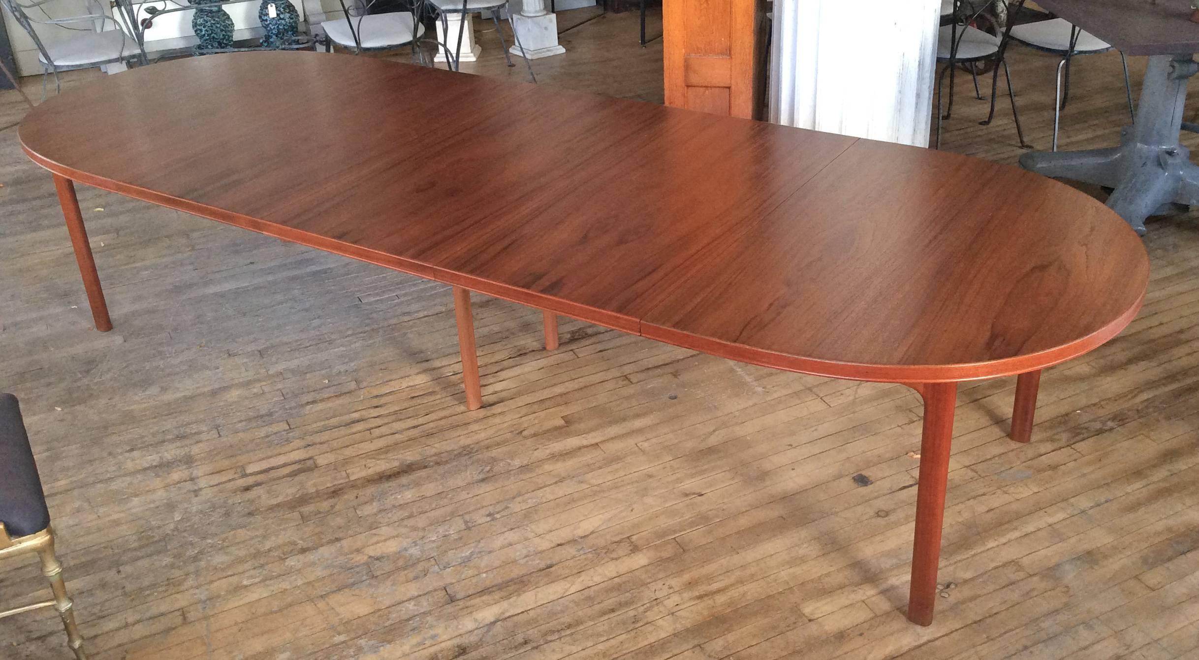 A beautiful vintage 1960s oval teak extension dining table by DUX, with three large leaves, giving the option of an full 11.5' table for the largest of parties. Stunning teak grain, and very solid and stable, with a hidden center leg that drops down