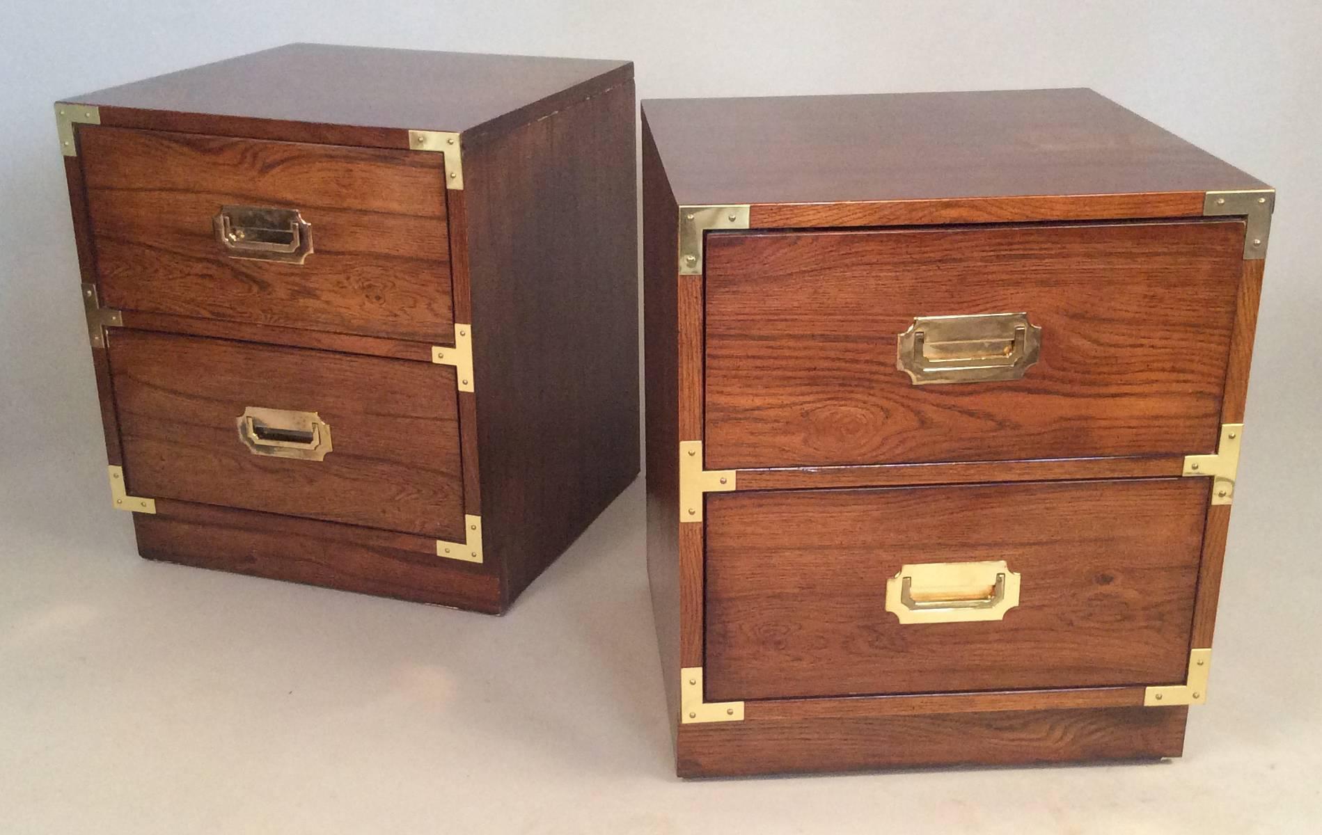 A very handsome pair of two-drawer campaign style nightstands by Bernhardt, with beautiful walnut graining and brass corners and hardware.