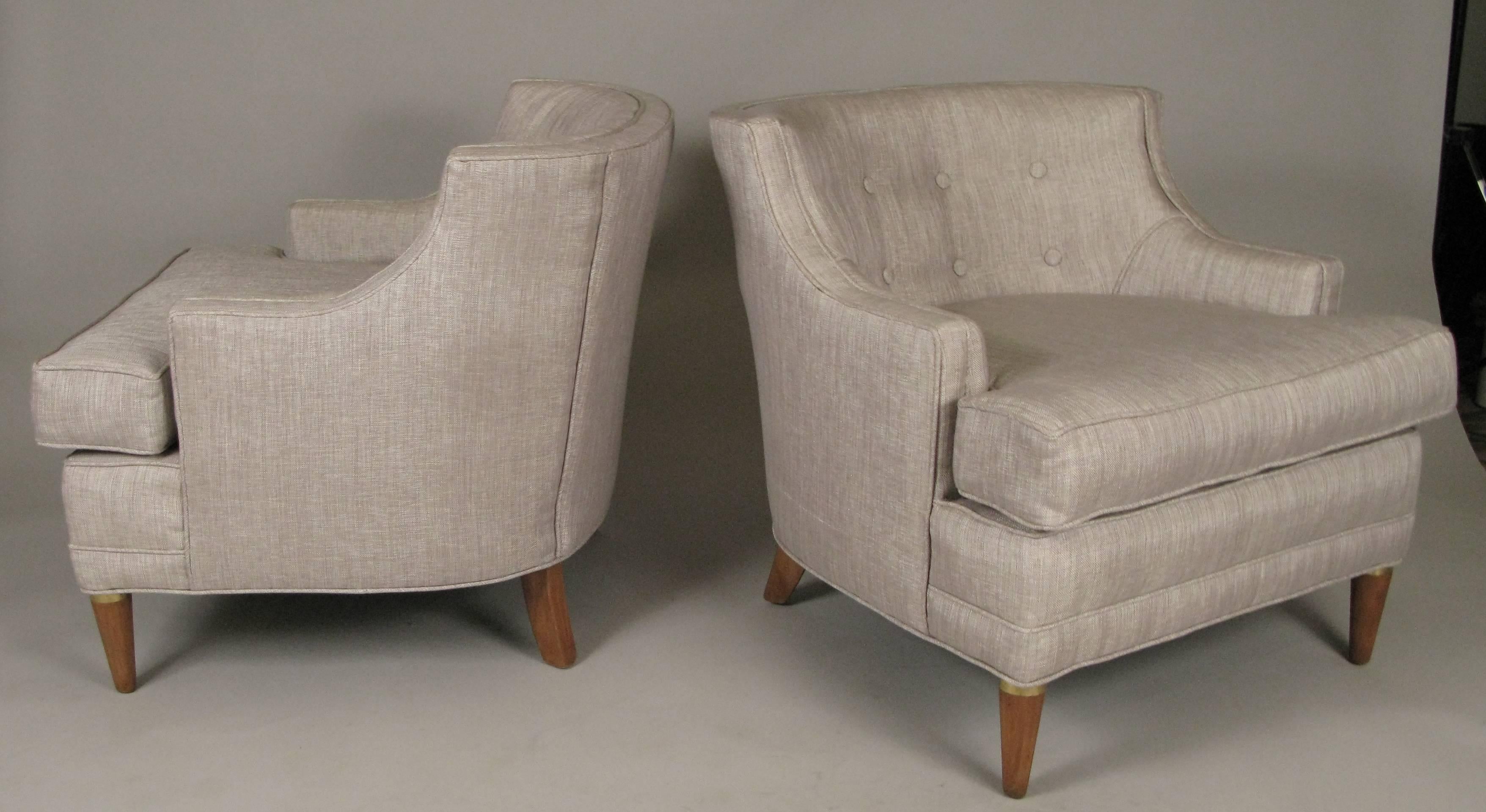 A very charming pair of vintage 1940s curve back lounge chairs, with beautiful scale and proportions. Extremely comfortable, just reupholstered with a very soft silver-grey fabric. Raised on polished walnut legs, with brass details.