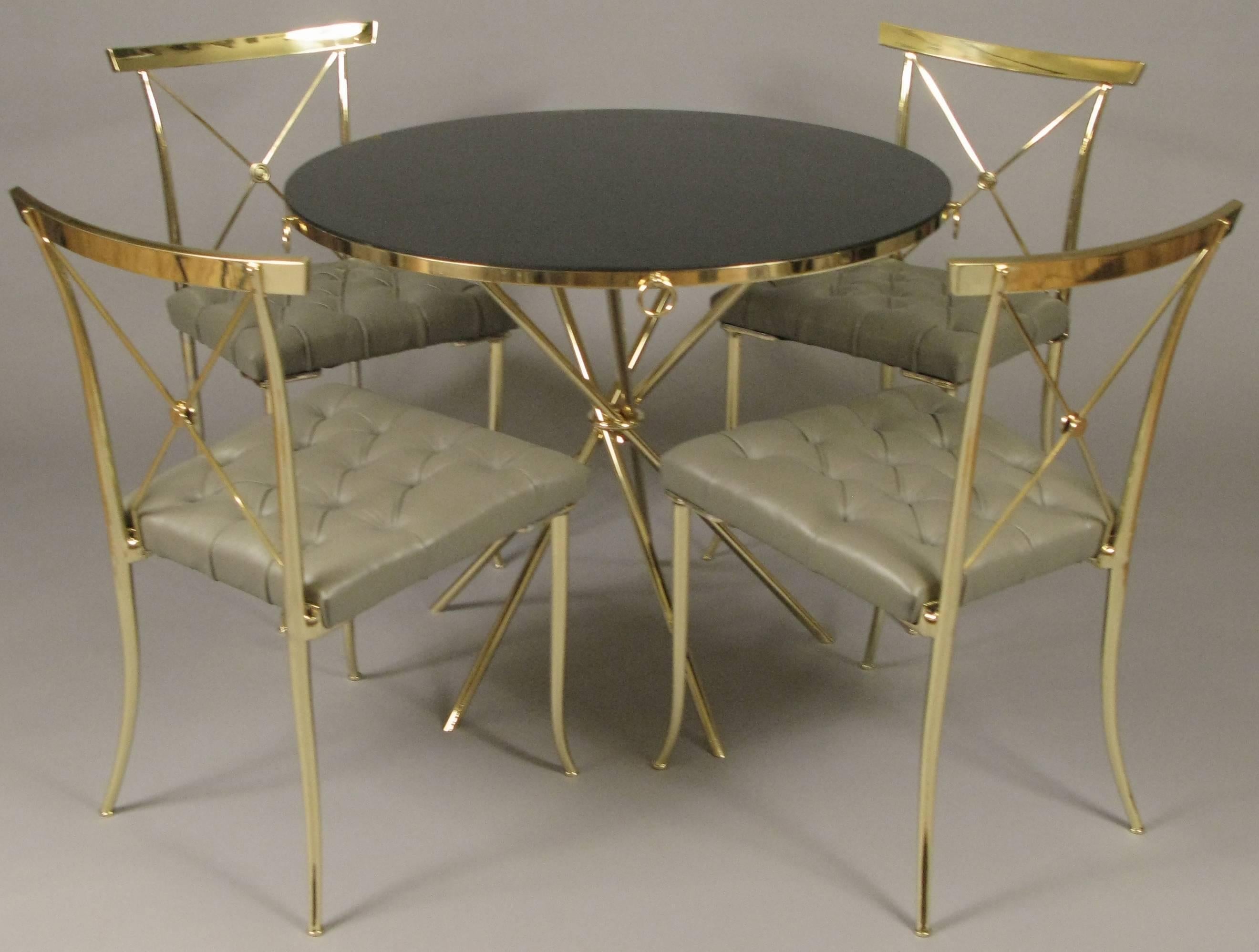 A stunning vintage 1950s brass dining set in the style of William 'Billy' Haines. The set includes four brass frame chairs with X-back with center medallion. The seats have just been reupholstered with the original pattern of deep button tufting in