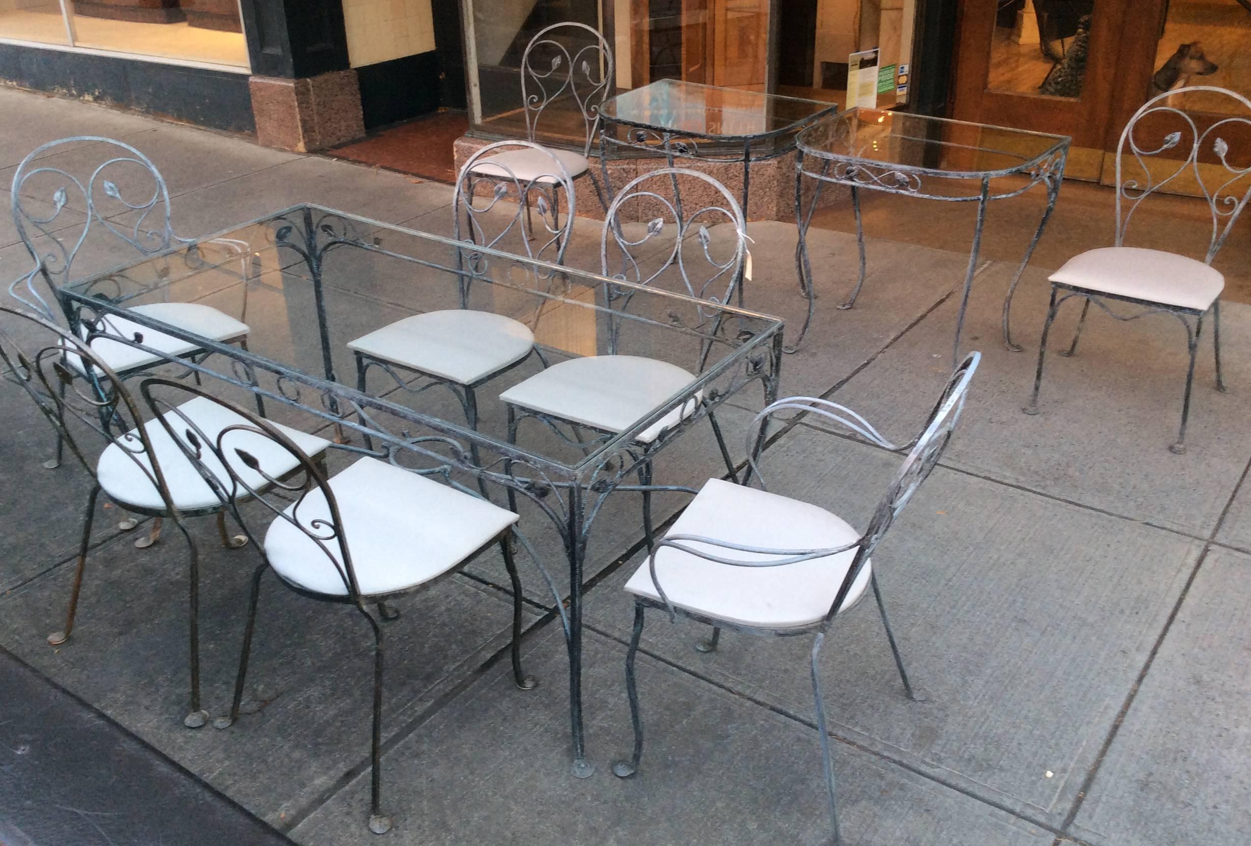 A very nice and versatile vintage 1940s wrought iron garden dining set by Salterini, with a large rectangular dining table and a total of eight matching chairs, including two armchairs. The set also includes the original pair of matching demilune