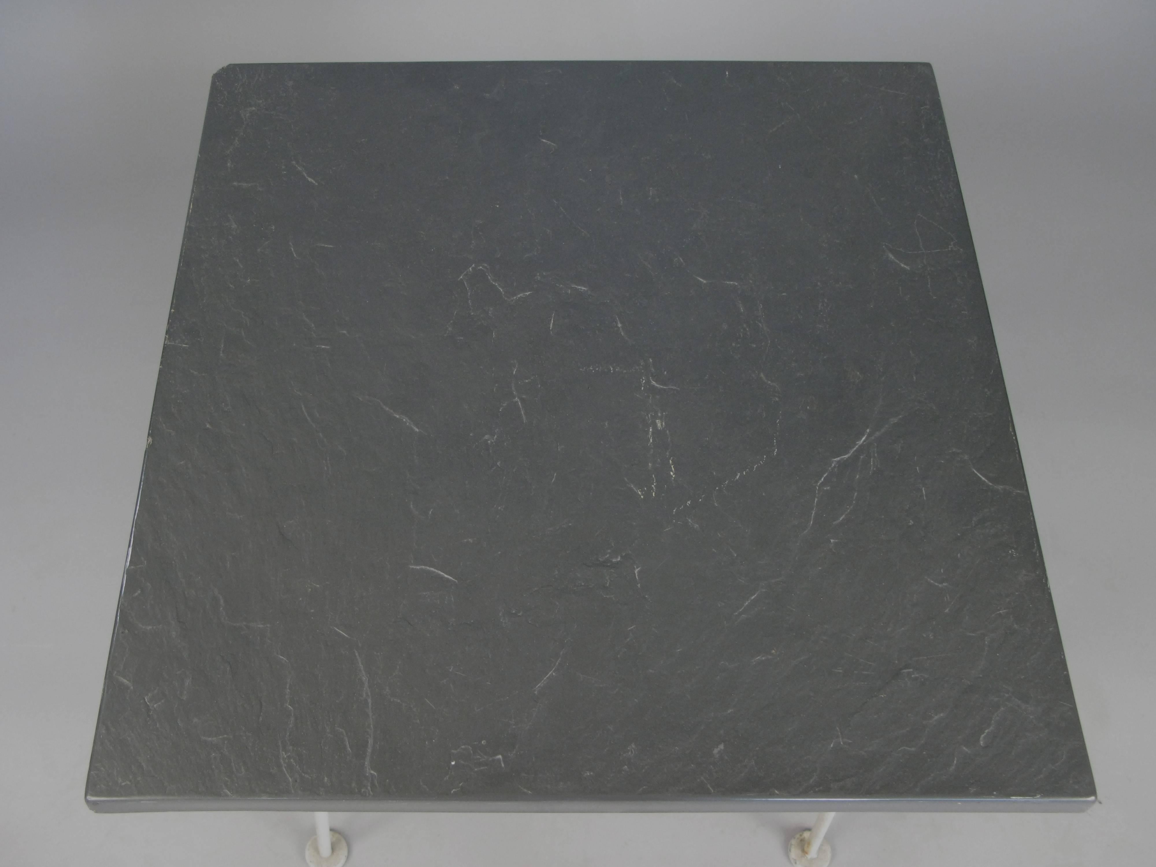 A rare sculptura side table by Russell Woodard,  circa 1950. Wrought iron base with a lower steel mesh shelf and it's original faux slate tabletop. Very good original condition with a chip to one corner of the top as shown.

We always have a