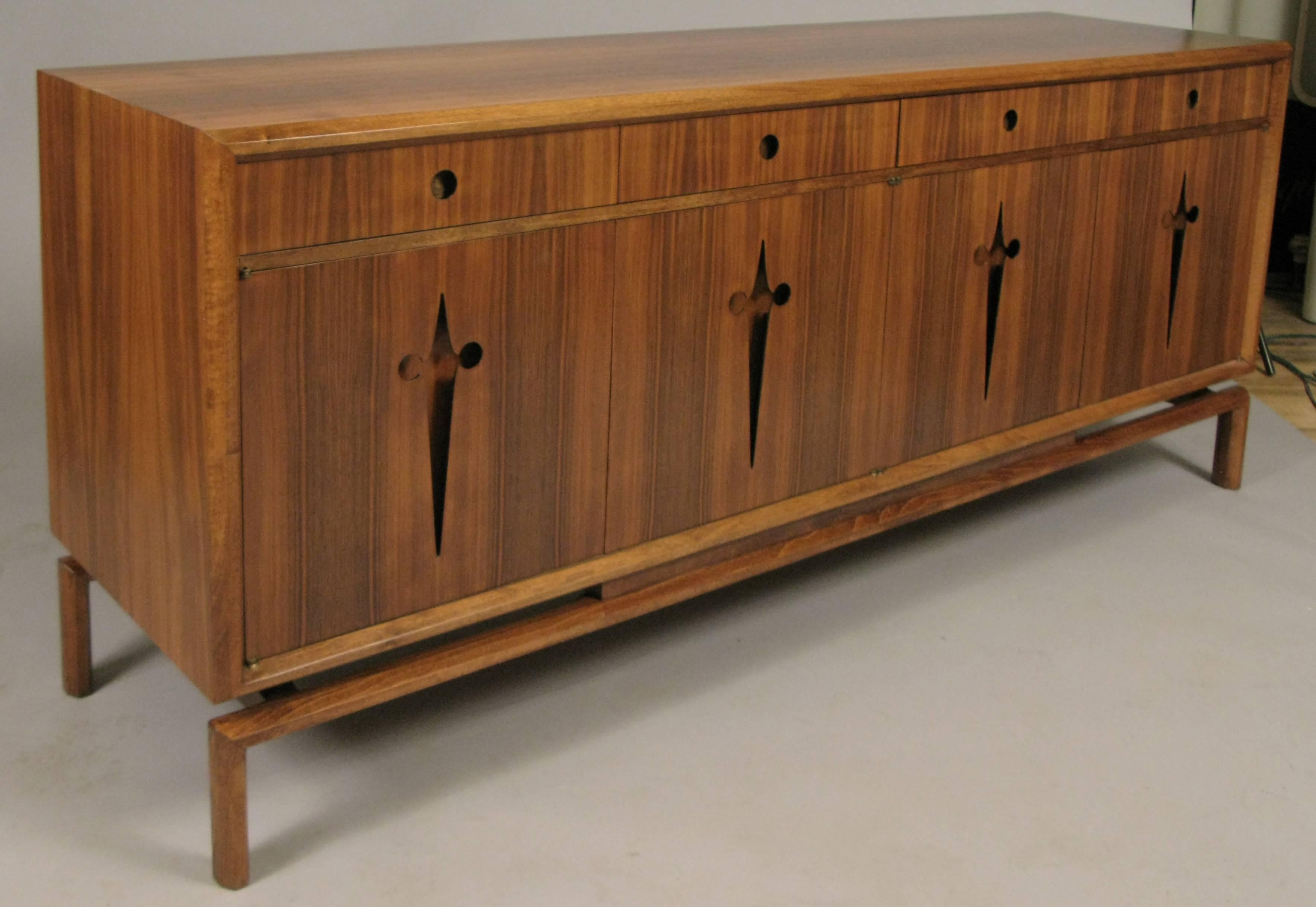A stunning vintage 1950s walnut credenza made in Sweden and designed by Edmund Spence. Raised on a floating base, with four doors concealing drawers and shelves, and four drawers across the top. The integrated handles are recessed and the lower ones