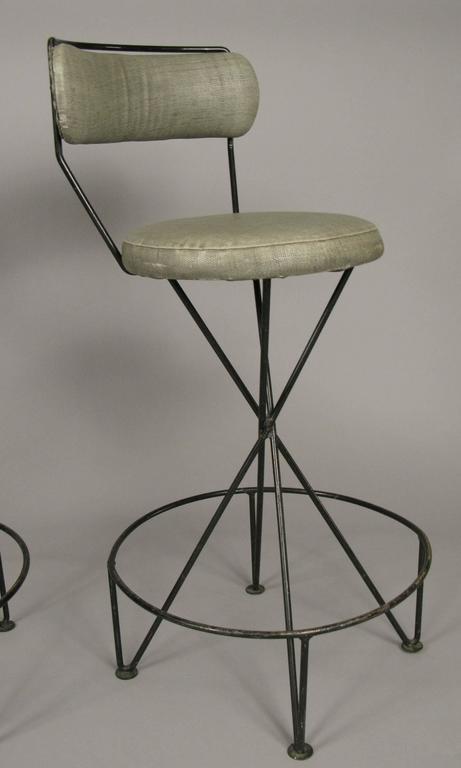 A very stylish set of three Mid-Century Modern wrought iron barstools, with curved and upholstered backs, and a full circular foot rail. 

A total of six barstools are available, priced and sold in sets of three.