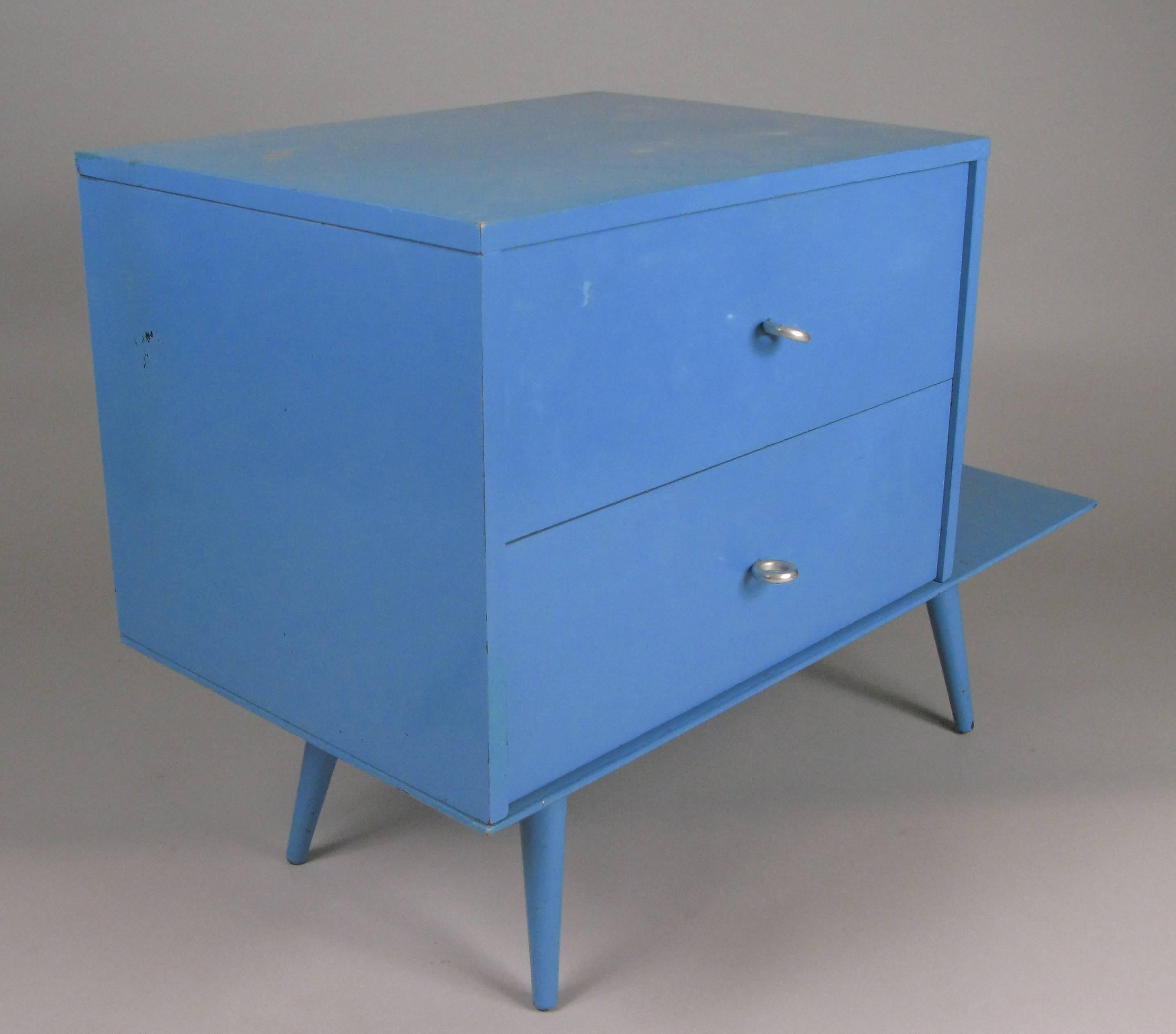 A matched pair of vintage 1950s planner group nightstands designed by Paul McCobb for Winchendon. each of the two drawer chests rests upon a bench/table base. these were painted blue years ago, and the painted finish is in good condition overall