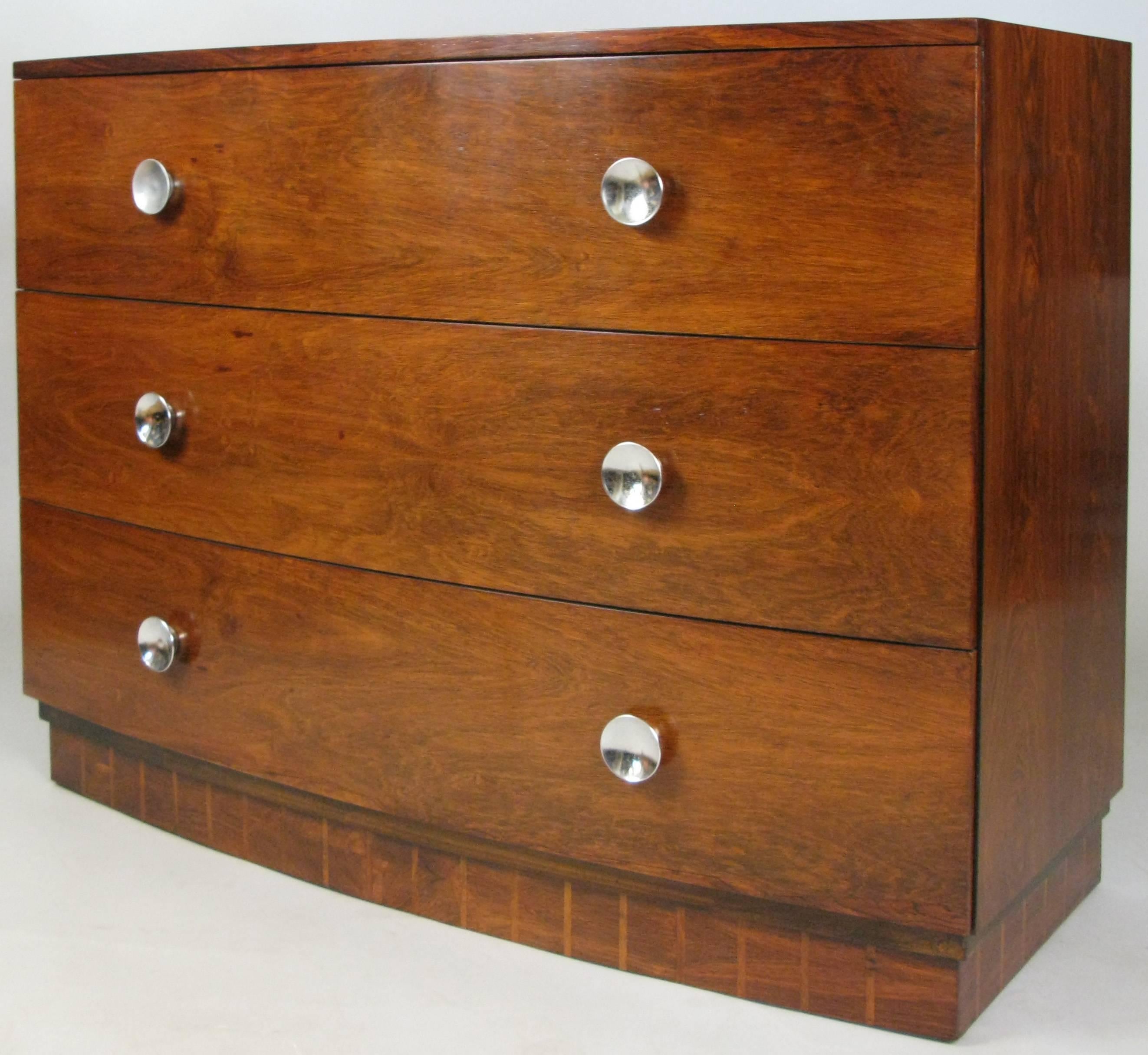 A Classic and stunning bow front rosewood three-drawer chest designed by Gilbert Rohde for Herman Miller. Raised on a recessed base with very nice detailing. Original chrome concave disc drawer pulls, and with the original small sliding valuables