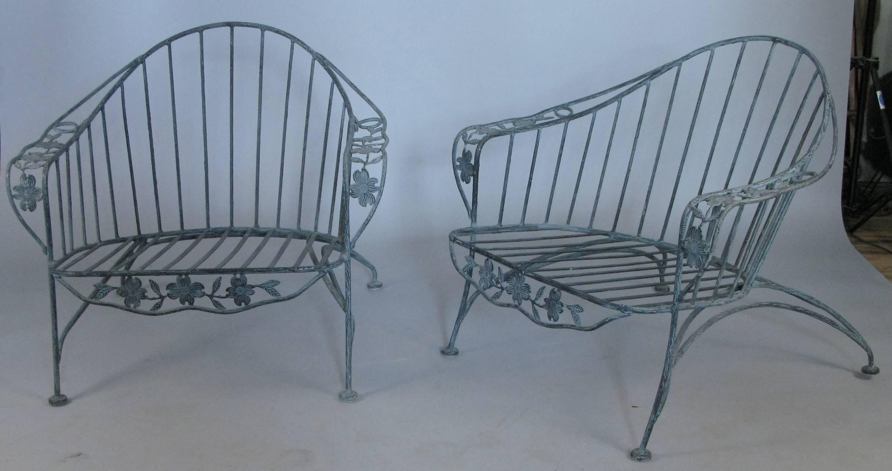 a very charming set of wrought iron lounge seating by Meadowcraft, consisting of a pair of large lounge chairs and a three-seat sofa, all with frames having a faux bois pattern and vines and leaves in the arms and under the skirt. Very well-made and