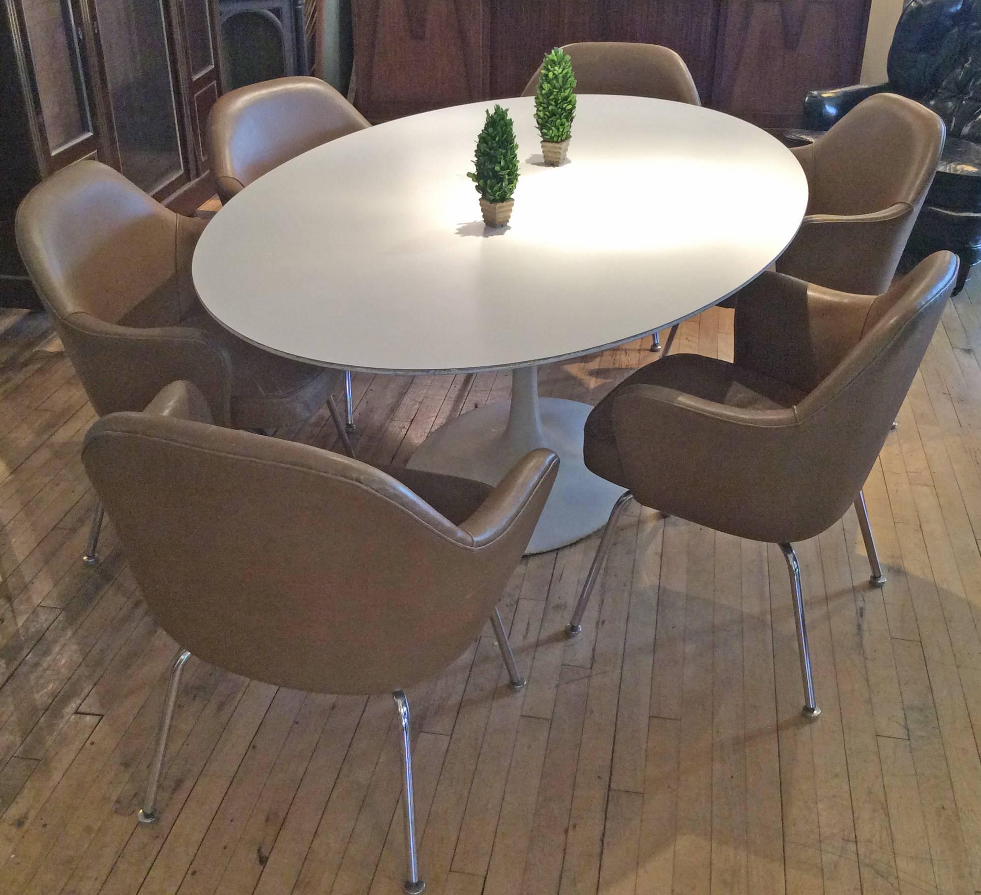A very nice and Classic vintage oval dining table designed by Saarinen for Knoll, with cast iron base and white laminate top. In good original condition with wear as expected around the edge of the table, and the original Knoll label.