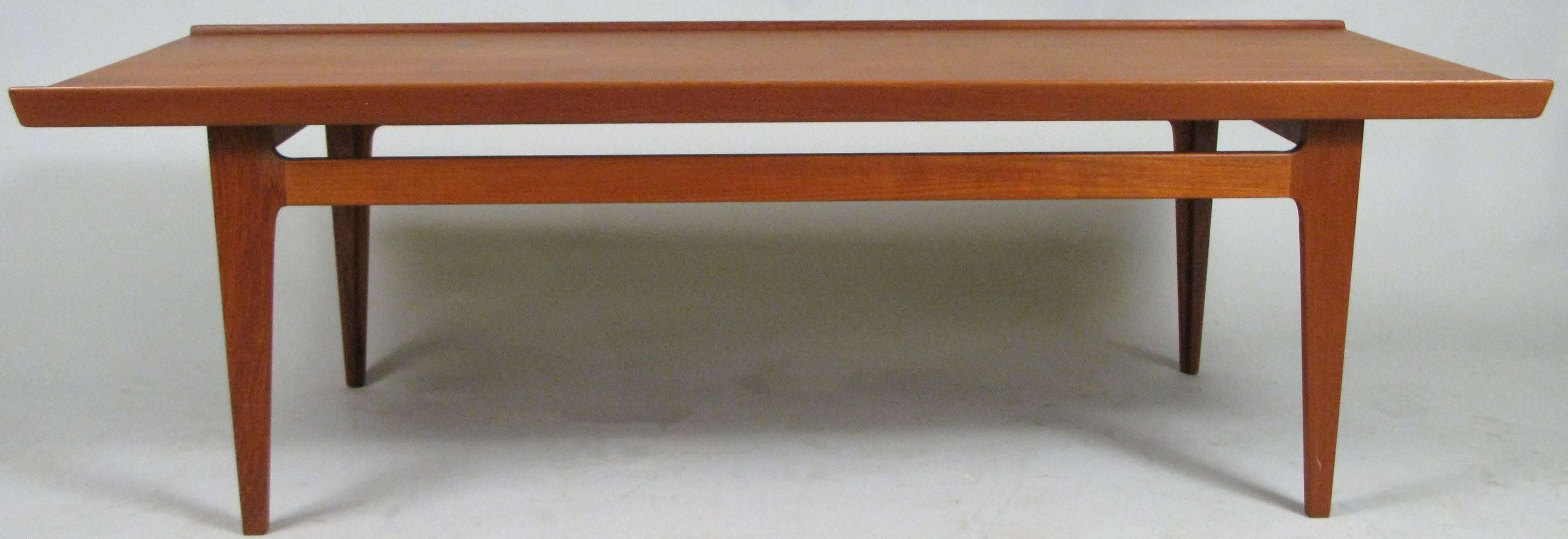 A very handsome vintage 1960s solid teak cocktail table designed by Finn Juhl, with subtle details including the raised edges, and beautiful wood grain. Stamped made in Denmark.