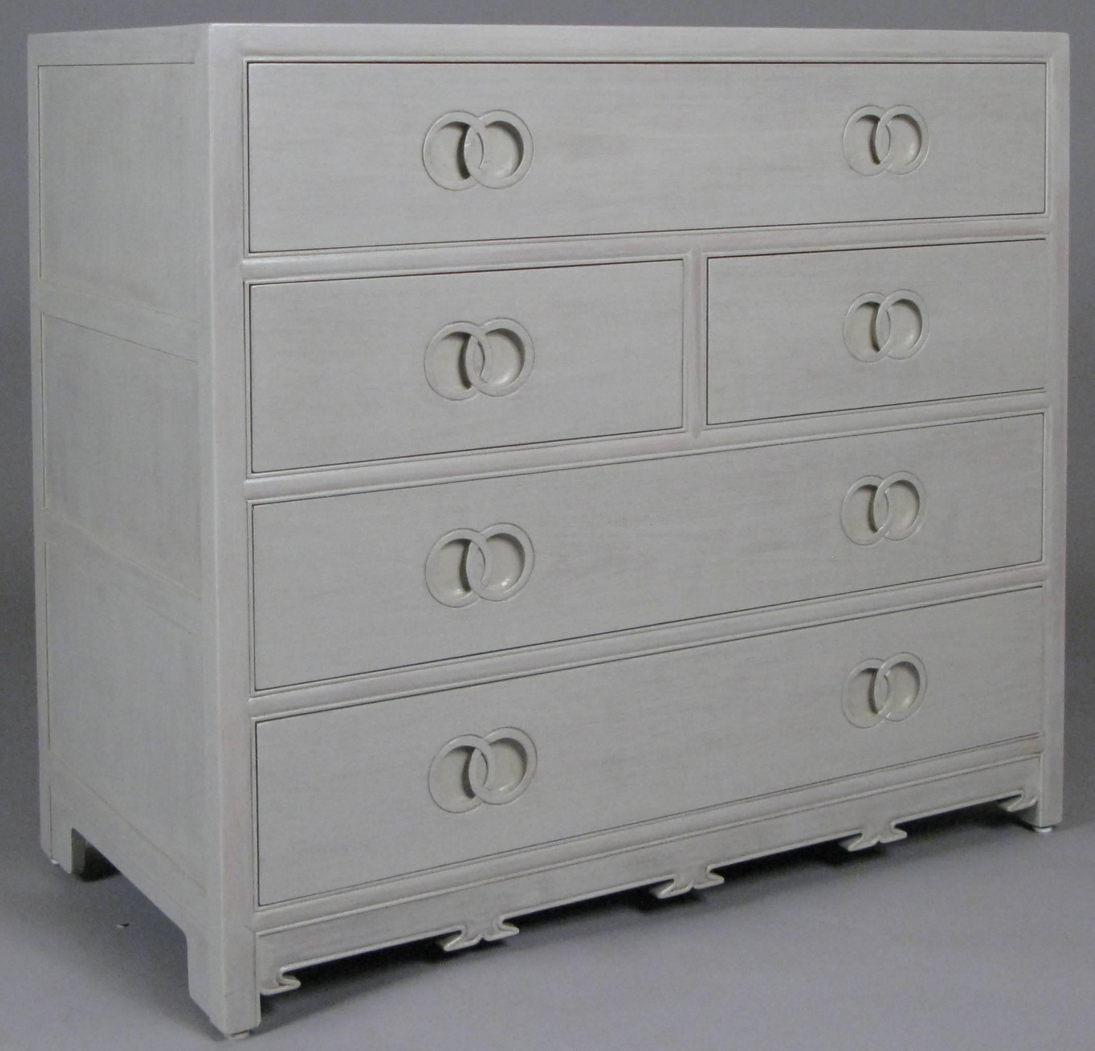 A beautiful and Classic vintage 1950s five-drawer chest designed by Michael Taylor for Baker Furniture with subtle recessed interlocking circle drawer pulls and details along the base as well. Some drawers are divided and the chest has just been