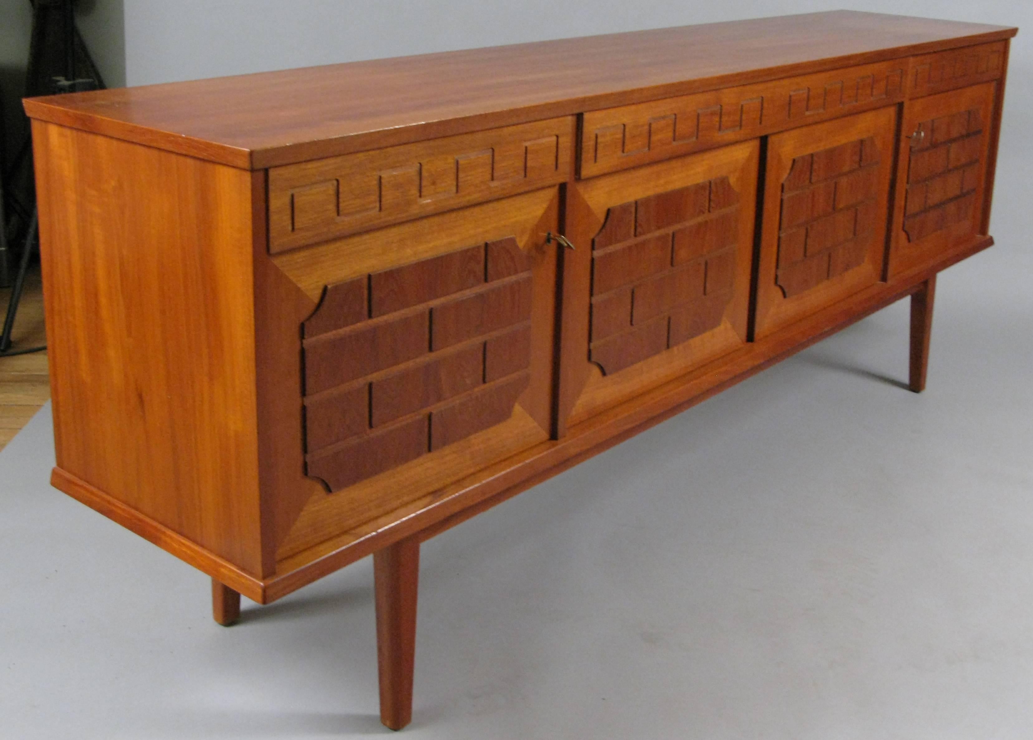 A beautiful 1960s Danish teak credenza sideboard cabinet, with very nice Greek key details on the drawer fronts, and a raised brick detail in walnut on the doors. Fitted interior with shelves and drawers. With original keys.
